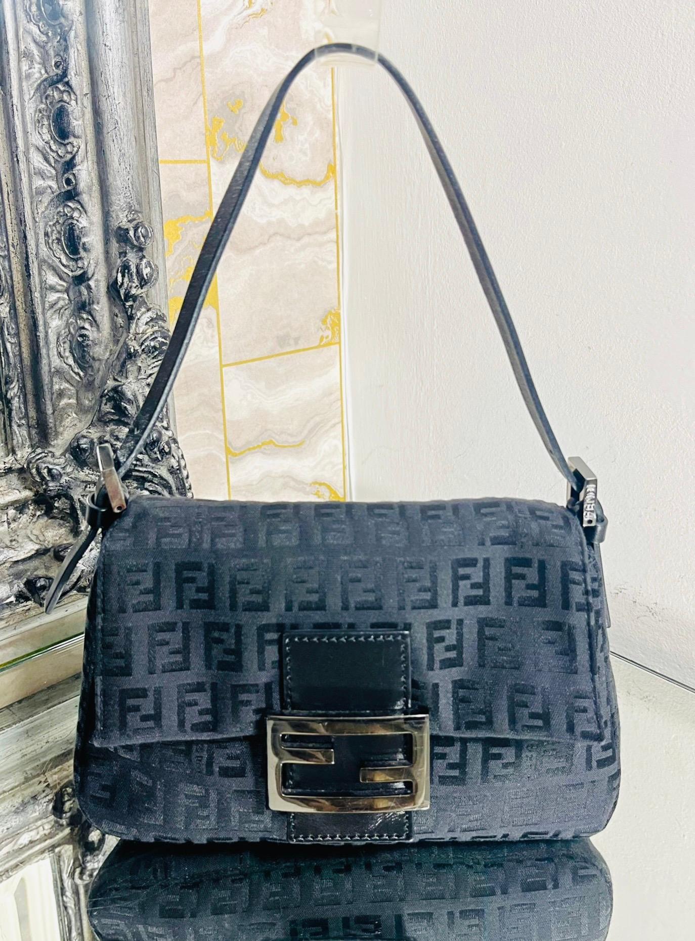 Fendi 'FF' Zucca Baguette Bag

Dark grey canvas handbag designed with signature Zucca print throughout.

Featuring silver, oversized 'FF' logo flap closure on black leather strap.

Detailed with adjustable shoulder strap with 'Fendi' logo engraved
