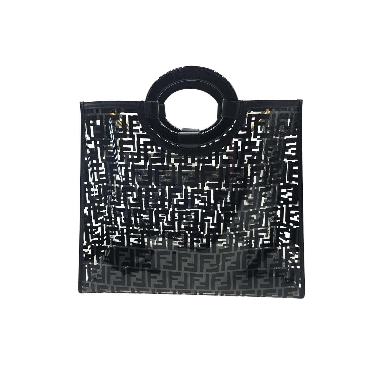 Questa shopper Fendi Defender è realizzata in poliuretano termoplastico trasparente con il motivo Black Zucca FF in nero e rifinita in pelle di vitello nera. Presenta una tasca frontale con cerniera, manici superiori in resina e finiture dorate. La