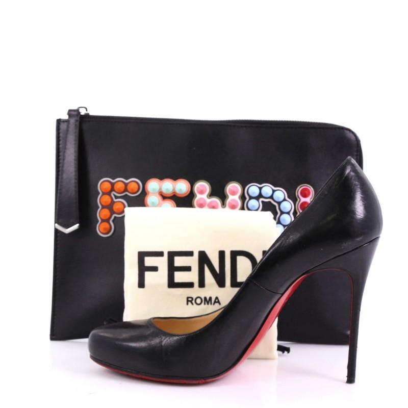 This Fendi Flat Clutch Studded Leather, crafted in studded black leather, features a top zip closure and silver-tone hardware . Its zip closure opens to a black fabric interior. **Note: Shoe photographed is used as a sizing reference, and does not