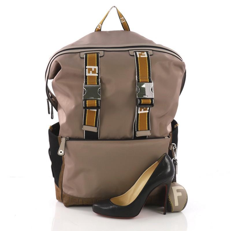 This Fendi Forever Utility Backpack Nylon with Logo Embossed Suede Large, crafted in brown nylon, features single top handle, shoulder strap, exterior slip and zip pockets and silver-tone hardware. Its zip closure opens to a black fabric interior