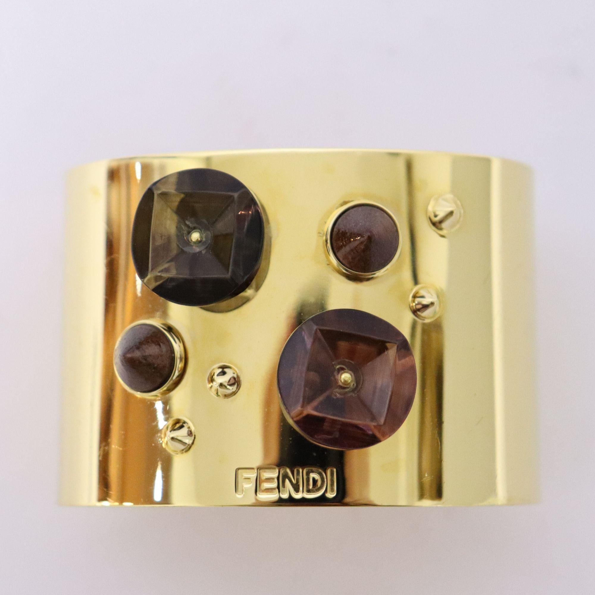 Fendi multicolored gemstone embellished with studs wide cuff bracelet. FENDI logo imprinted on the bottom.

Measurements: (Approx.)
Height: 5.5cm
Length: 17cm
Overall Condition: Scratches.
