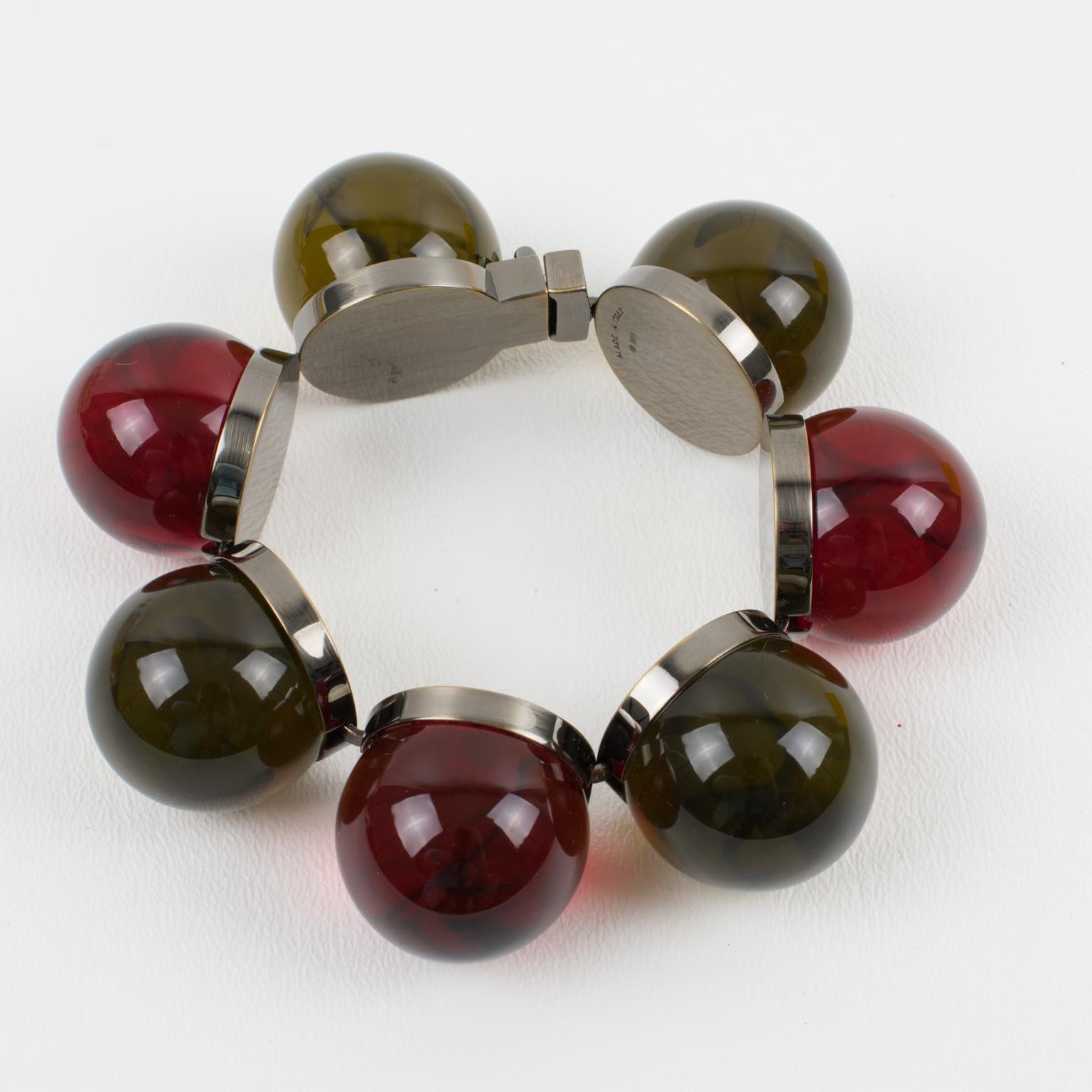 La Casa Fendi, Italia, ha diseñado esta impresionante pulsera brazalete. Esta rara pieza está hecha de eslabones engarzados en metal con acabado bronce de cañón, adornados con grandes cuentas 