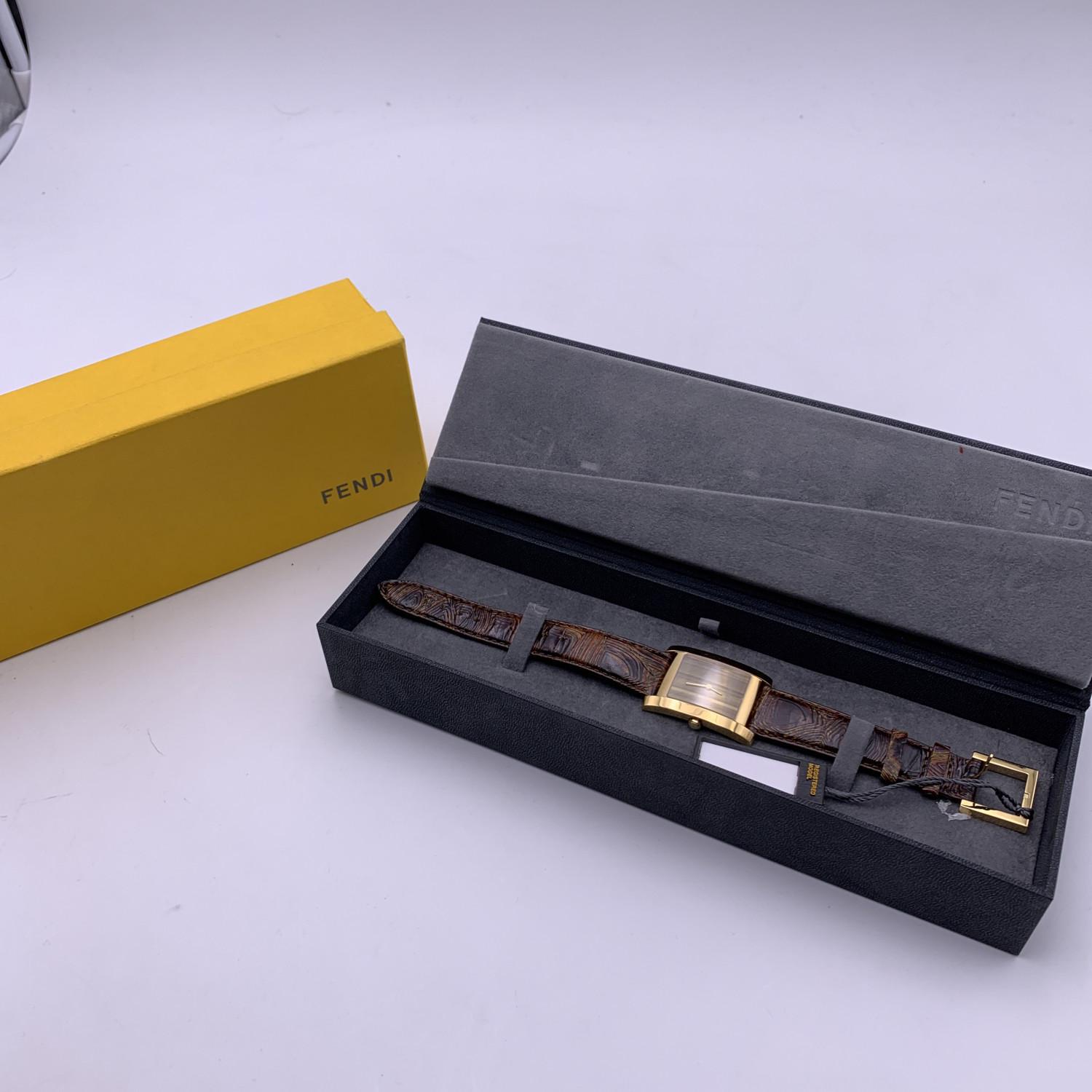 Beautiful Fendi watch, Mod. 7000 G. Rectangle gold plated stainless steel case. Brown striped dial (tiger eye look). Gold metal hands. Scratch resistant sapphire crystal. Swiss Made Quartz movement. Brown leather strap with buckle closure. Water