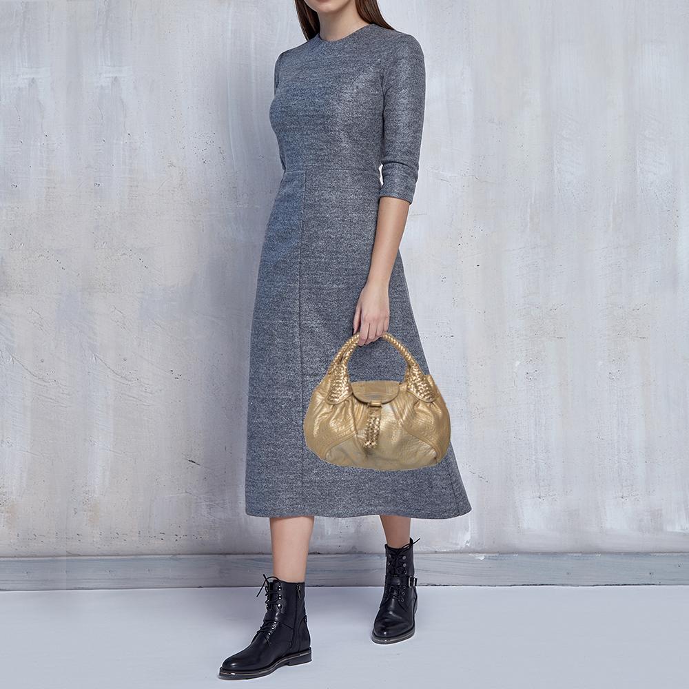 Diese schicke Spy-Tasche ist von Fendi. Die Tasche ist aus Leder gefertigt und hat zwei geflochtene Griffe an der Oberseite. Die Tasche ist mit einem Innenraum aus Stoff ausgestattet, in dem alle wichtigen Dinge des Alltags Platz finden. Zeigen Sie