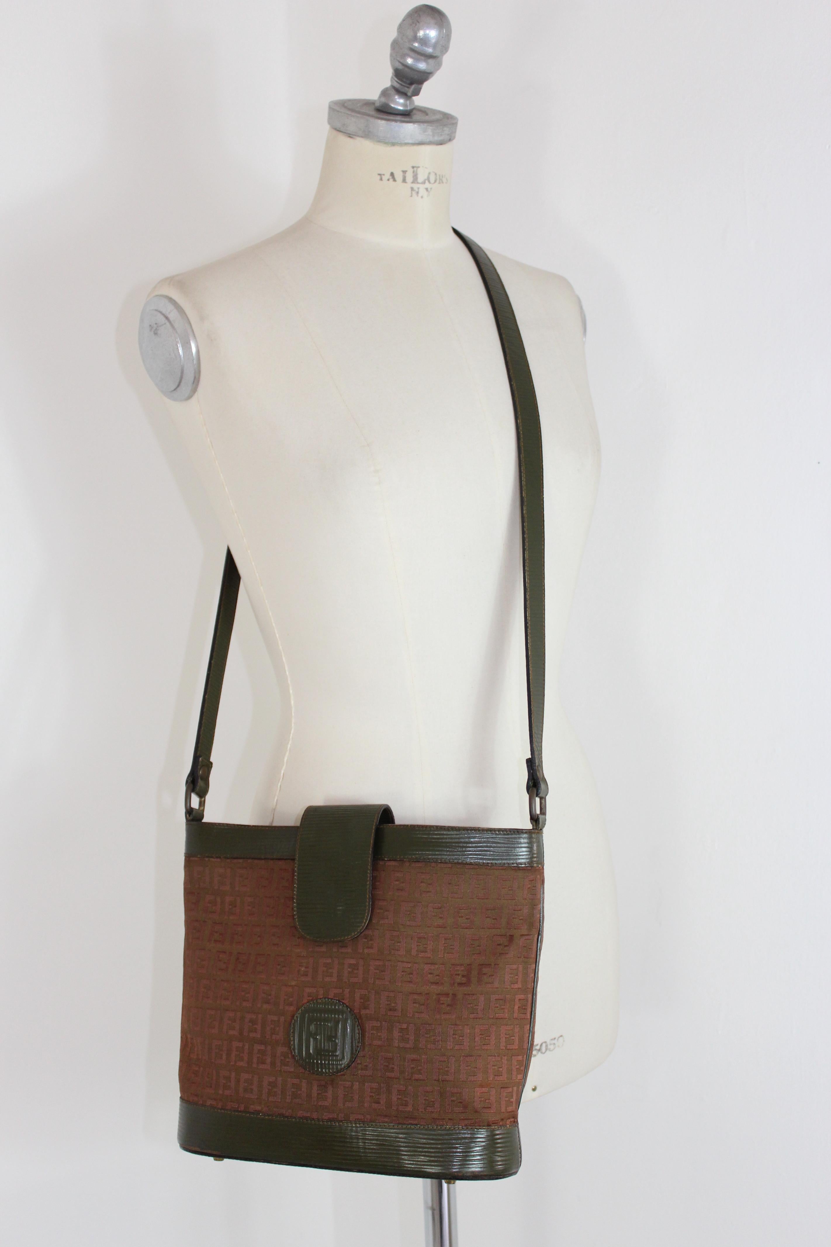 Fendi vintage 80s bag. Shoulder bucket bag, zucca monogram pattern, typical of the fashion house. Green and beige color. Fabric in leather and canvas. Closure with clip button. Adjustable shoulder strap. Made in Italy. Very good vintage condition,