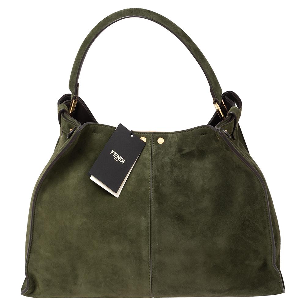 This exquisite Peekaboo X-Lite bag from Fendi is a great update of an iconic design. This version comes meticulously crafted from green suede and is designed with a top handle for you to swing it in style. A twist-lock opens grandly into a