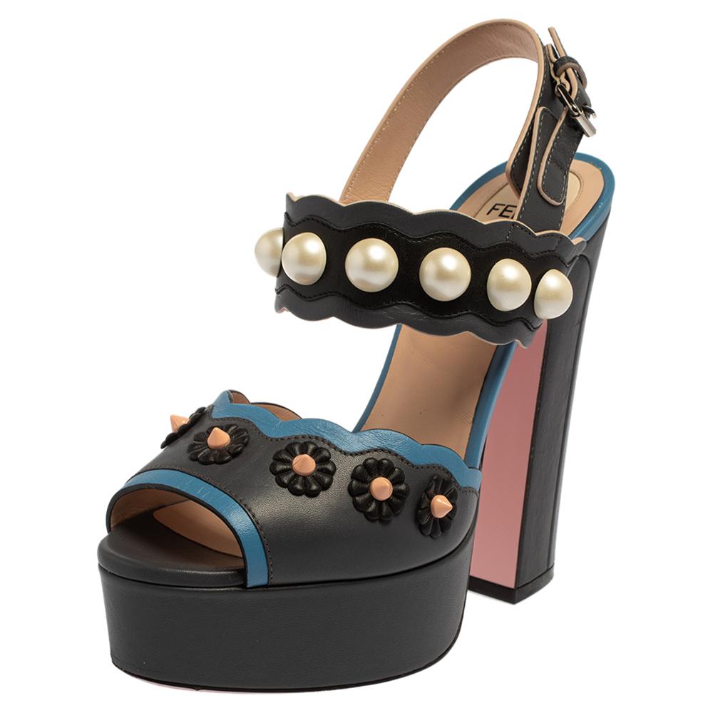 Every woman needs a mesmerizing pair of sandals in her closet. These Fendi sandals are just the perfect choice. They have been made from grey-hued leather and designed with pearl studs, buckled ankle straps, and 13 cm block heels supported by