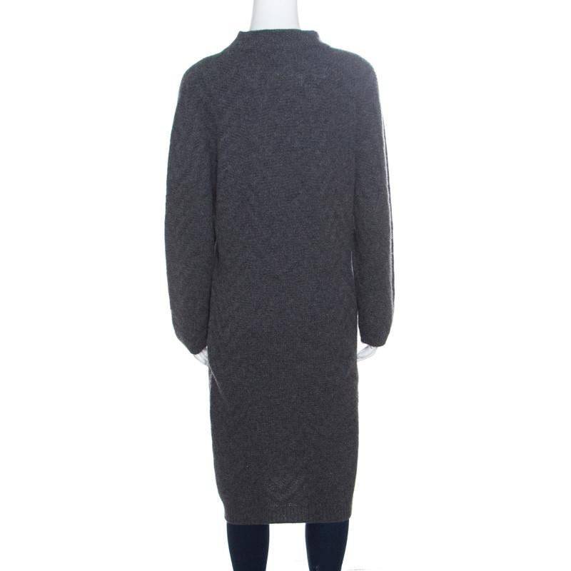 This lovely sweater dress from Fendi is perfect for the fashionable you! The grey creation is made of 100% cashmere and features a chevron patterned knit design. It flaunts a high neck and long sleeves. Sure to lend you a good fit, it can be paired