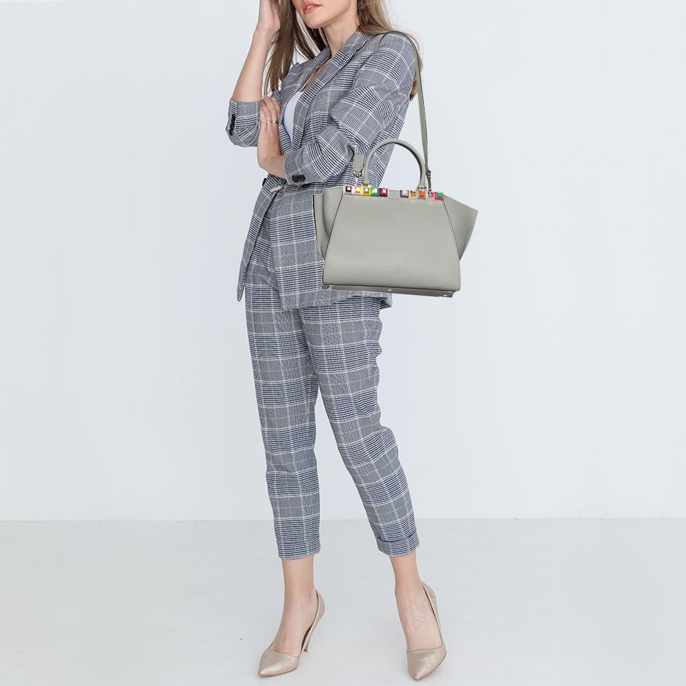 Fendi brings you this stunning update of their famous 2jours bag, the 3Jours! Crafted from leather, the grey bag has two handles and a gorgeous embellished bar. The insides are leather-lined and spacious enough to carry all your