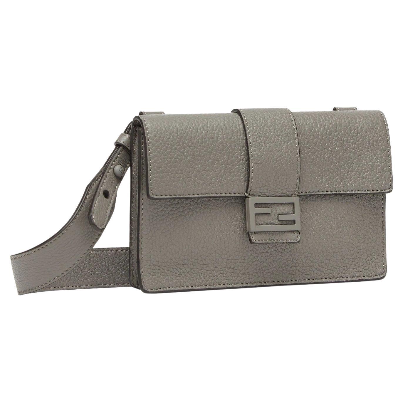Baguette pouch with square flap and FF magnetic clasp. Can be worn on the waist, over the shoulder or cross-body by attaching the removable strap. Inside: lining with zipped pocket.