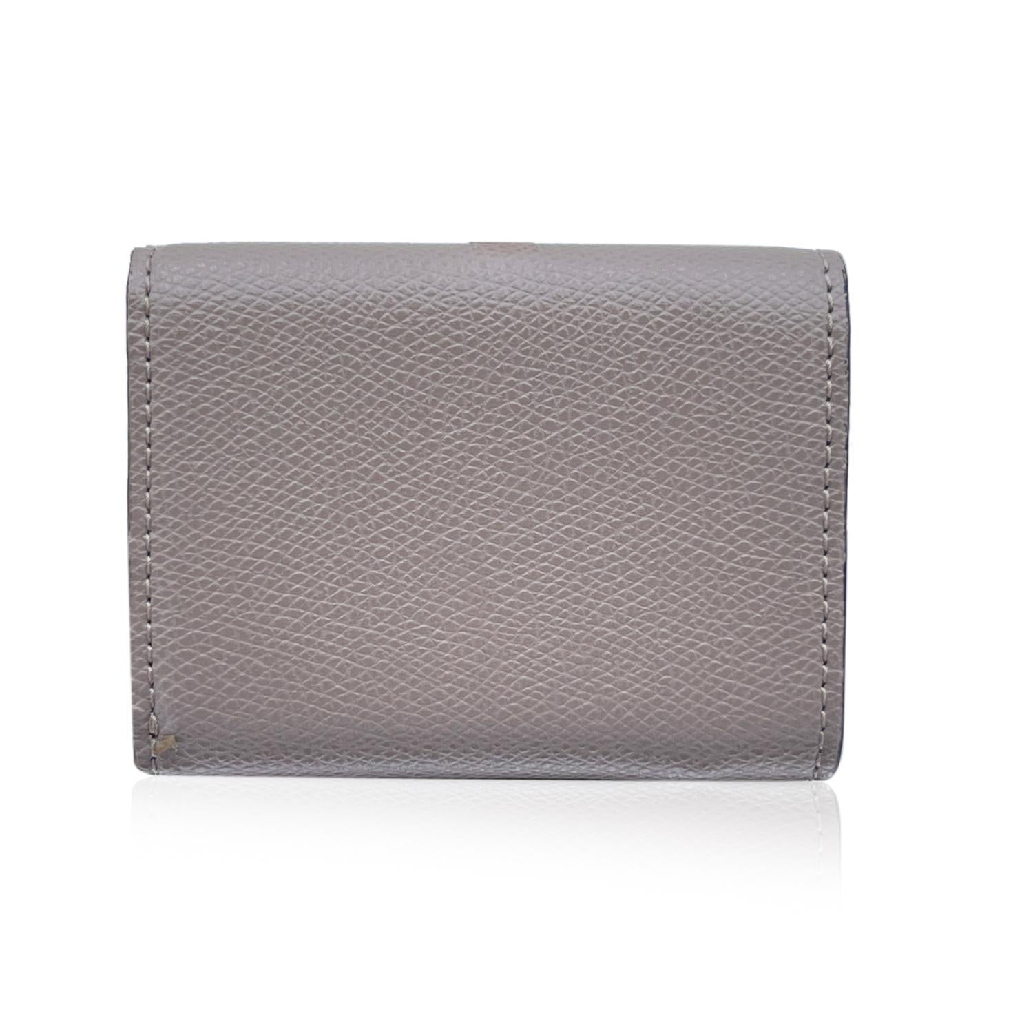 Fendi 'F is Fendi' tri-fold mini wallet with a compact design, it features with an internal compartment for bill and 3 hidden card pockets. 1 coin compartment closed with a snap button. Made of grey leather. Gold metal F logo on the front. 'Fendi -