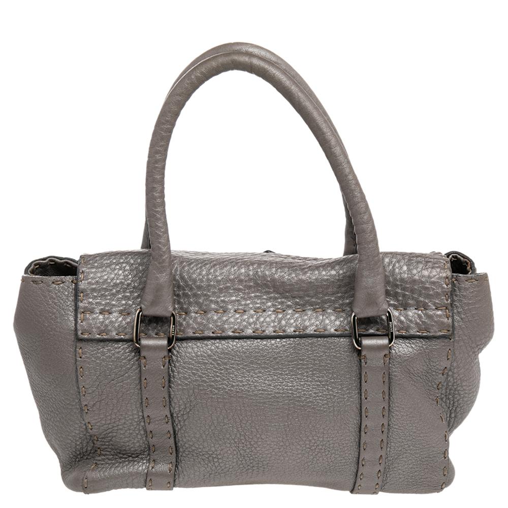 Perfect to tote at work, this 'Linda' satchel from Fendi is a must-have! Crafted in leather, the bag features dual-rolled handles, silver-tone hardware, protective metal feet, and the signature charm. The grey satchel opens into a canvas-lined