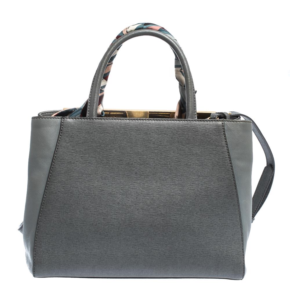 Fendi's 2Jours tote is an iconic design. Crafted from grey leather, the bag features a metal bar, a twilly wound around one of the rolled handles and a shoulder strap that's detachable. A button closure opens to a fabric-lined interior that houses