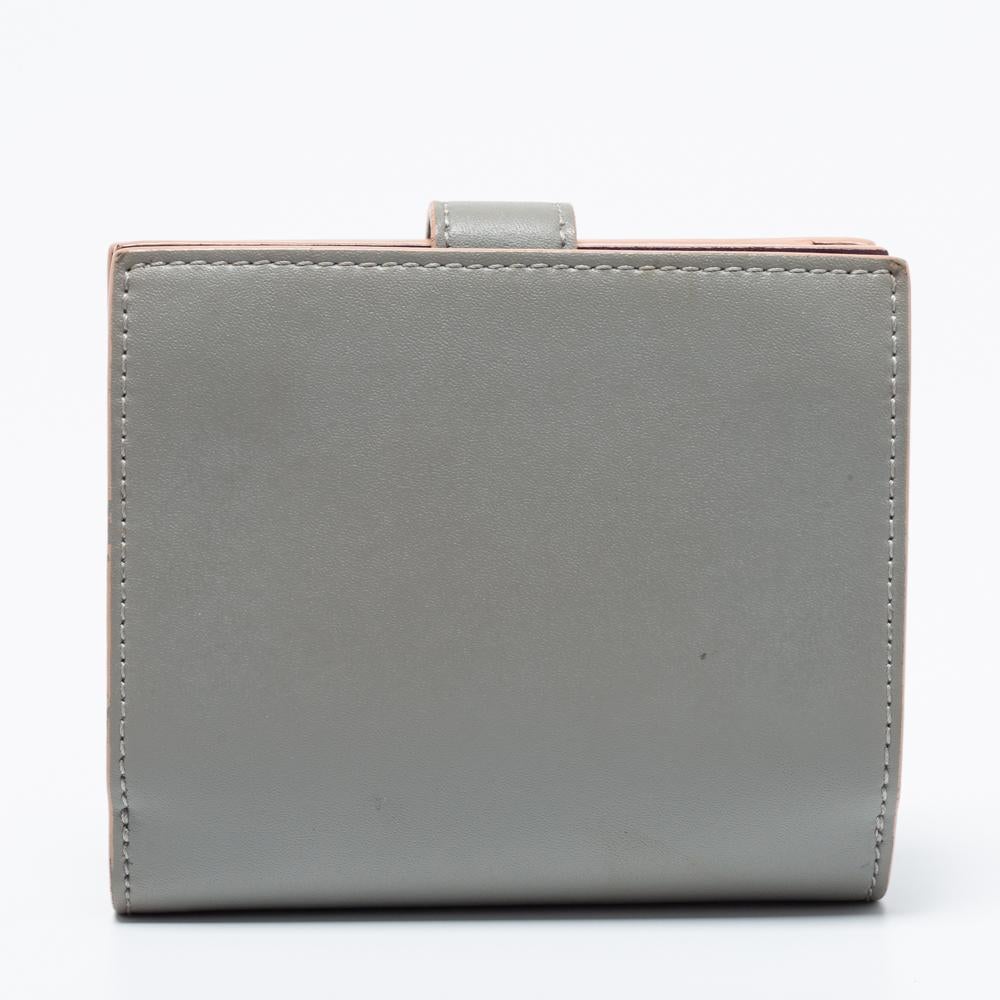 This wallet from the house of Fendi is the most classy way to organize your essentials. It is made from grey leather on the exterior. The compact style and studded band strap reveal a neatly designed interior, which can house your cards and currency