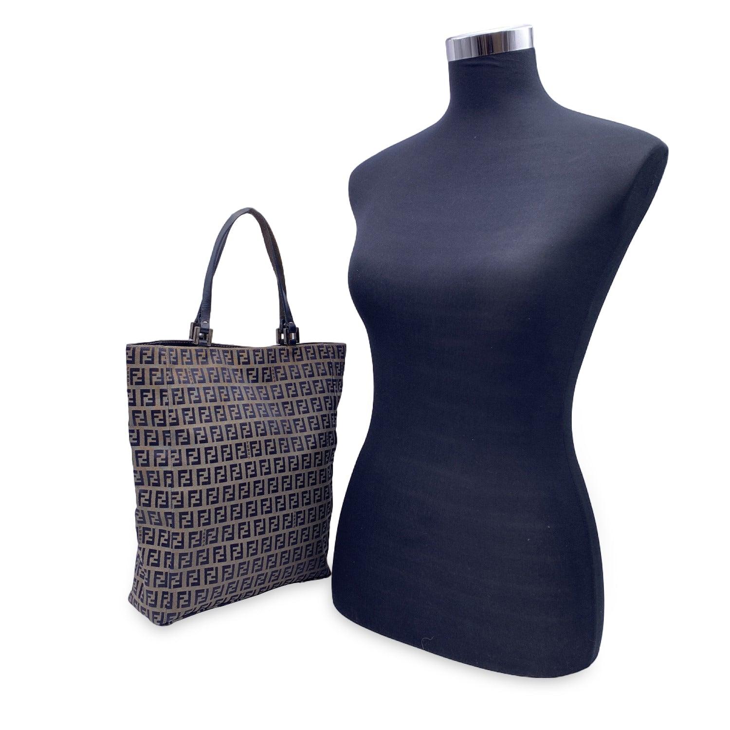 Fendi tote bag crafted in Grey and navy blue monogram canvas with navy blue genuine leather shoulder straps. Magnetic button closure on top. Blue satin lining. 1 side zip pocket inside. 'Fendi - Made in Italy' tag inside. Serial number embossed
