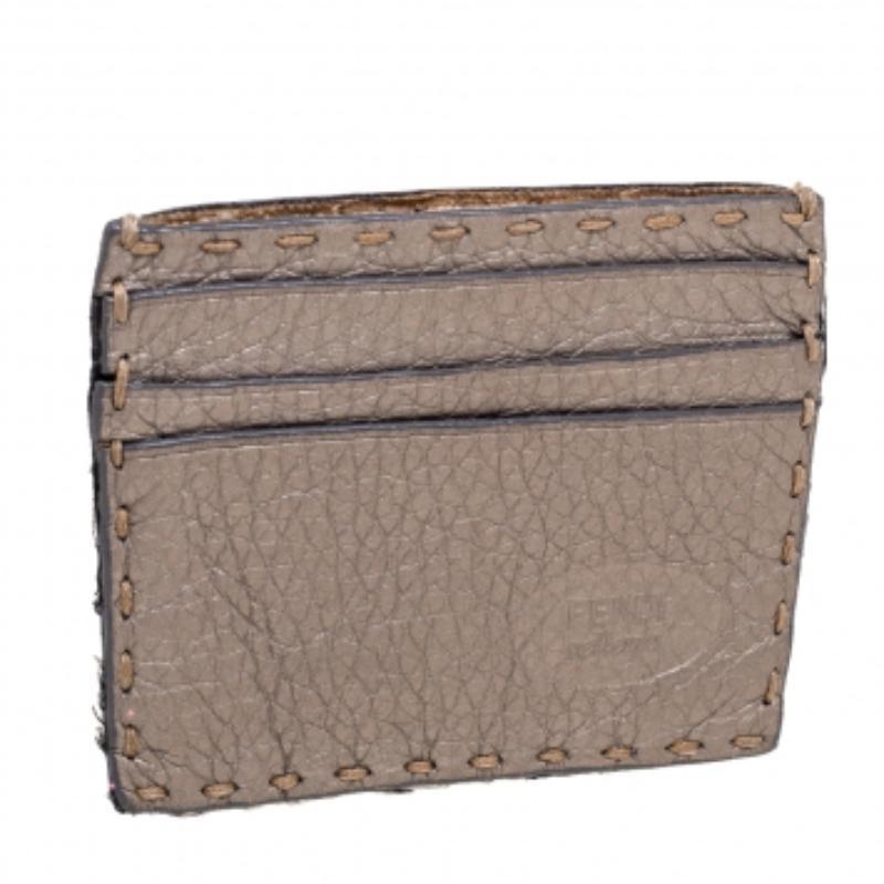With this classy card holder from Fendi, your essentials need not be mundane anymore. Featuring a grey Selleria leather, this card holder grants enough slip pockets for storage. It has a canvas-fabric interior. This piece can house all your