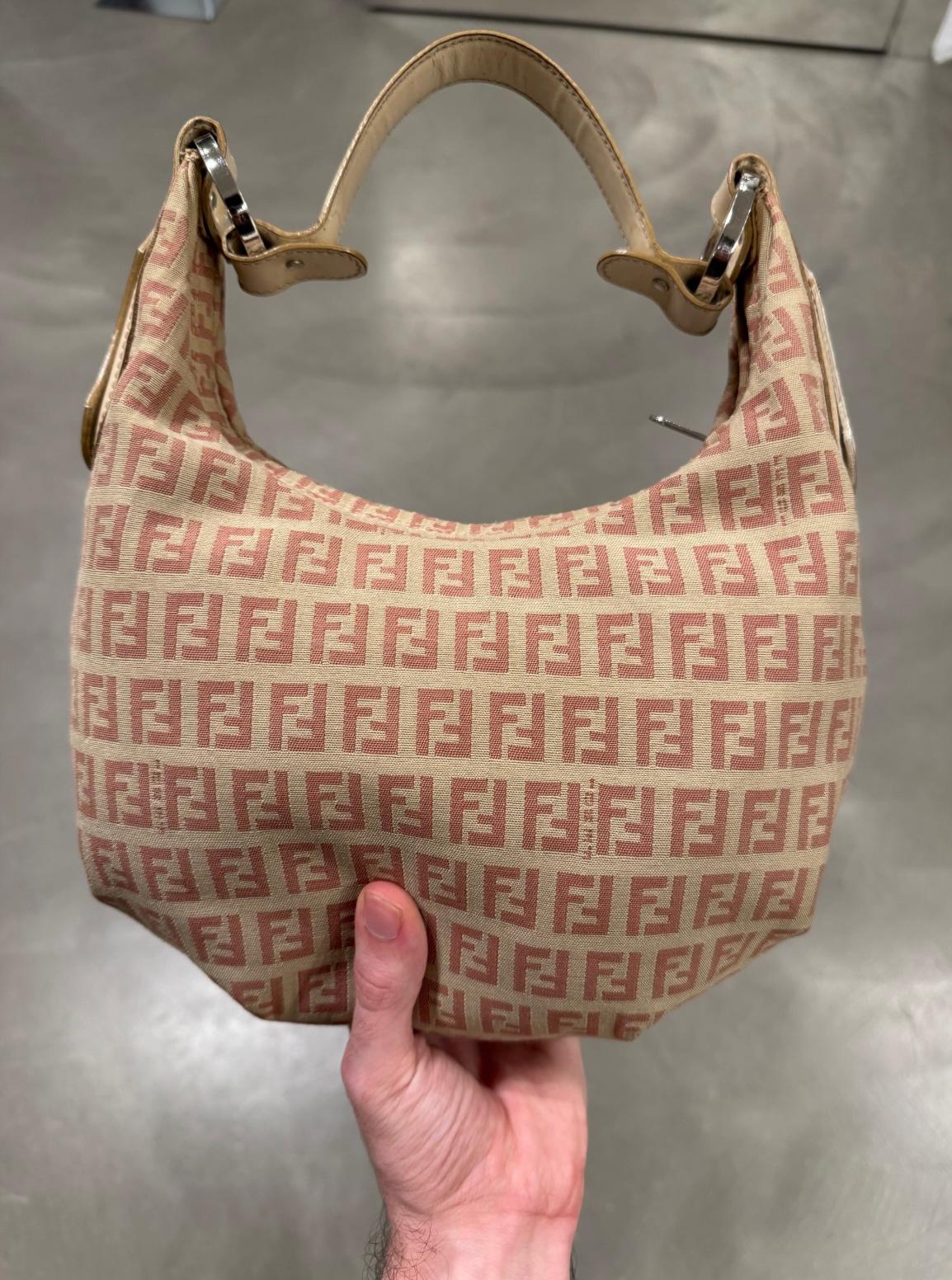  Borsa Hobo di Fendi

Questa borsa Hobo di Fendi è un pezzo intramontabile, caratterizzato dall'iconico Monogram FF in una morbida colorazione beige e terracotta. Progettata con una silhouette sciancrata ma strutturata, è realizzata in tela jacquard