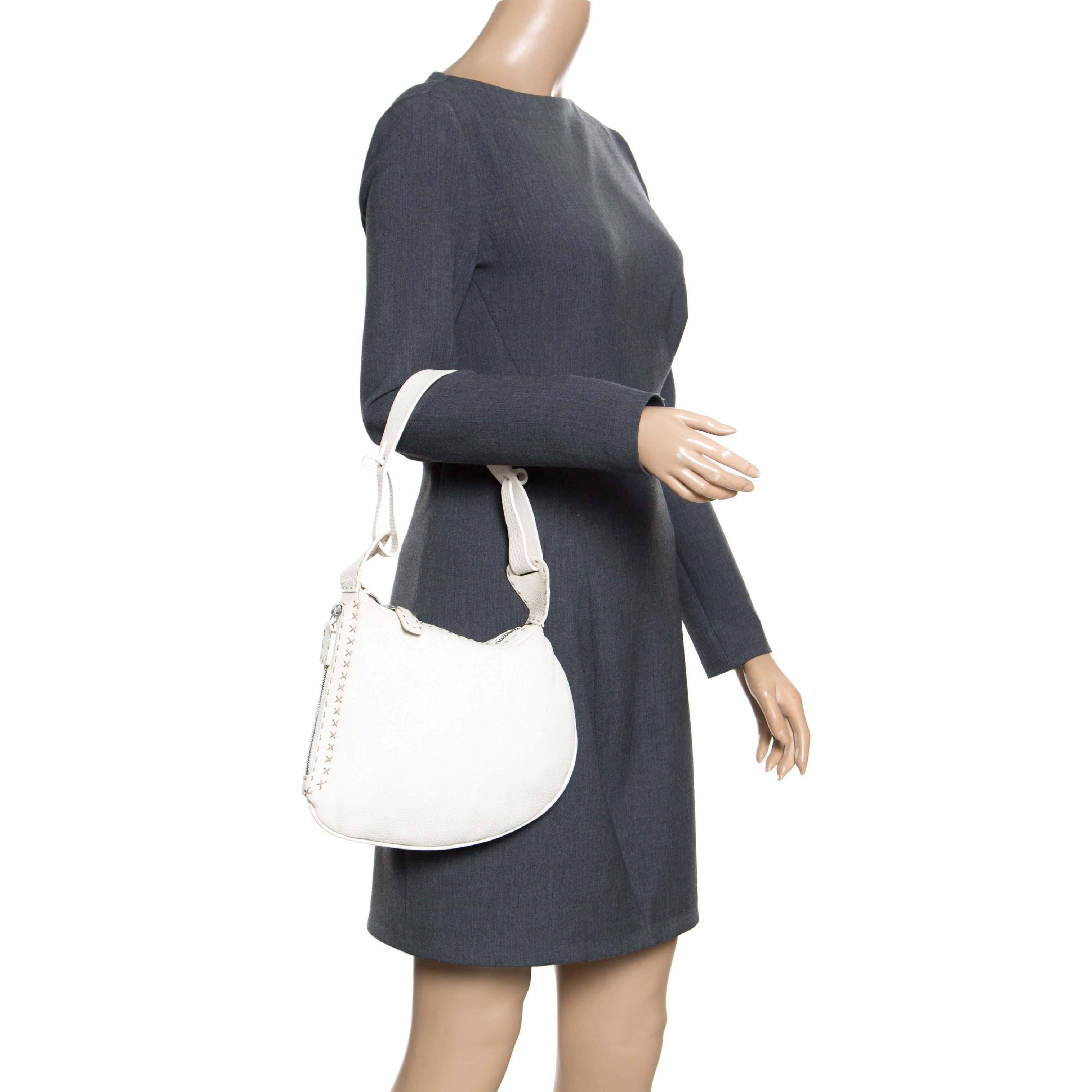 This stylish Oyster hobo is crafted to perfection with pebbled white leather in the shape of an oyster and is adorned with hand-stitched details at the corners. The bag features an end to end shoulder strap and a top zipper closure. The bag opens to