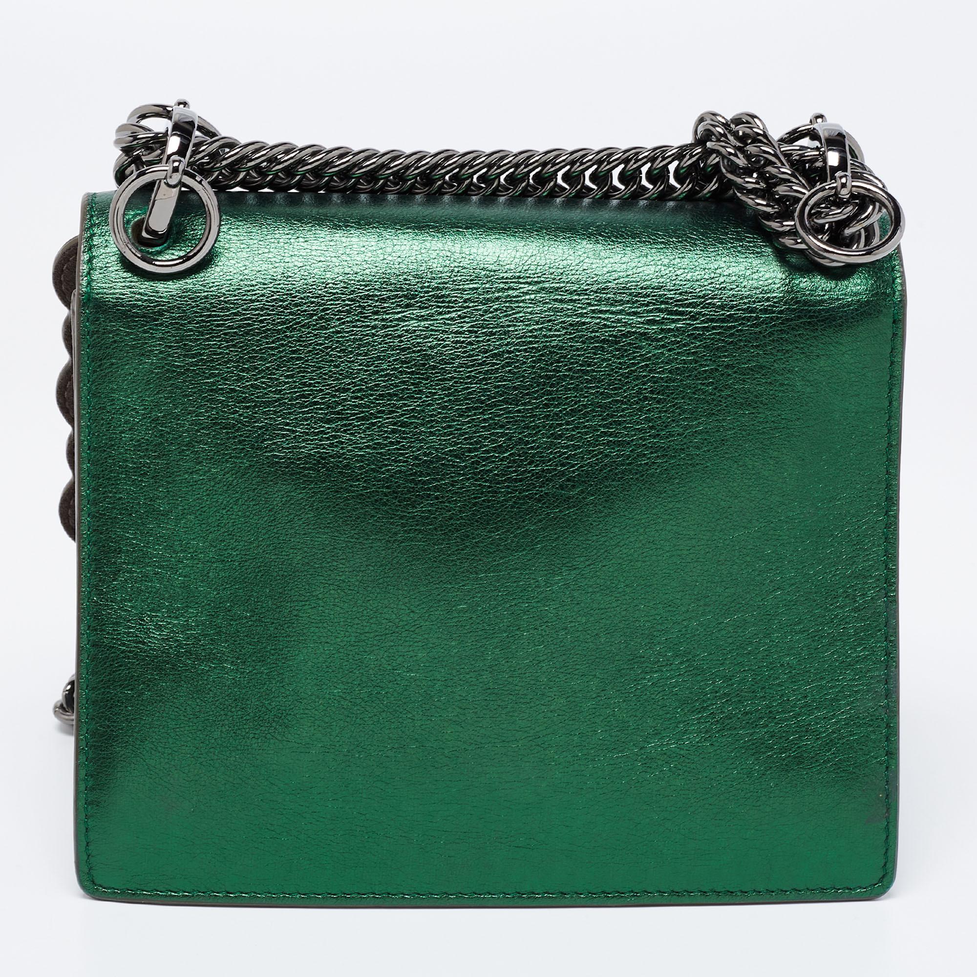 This Kan I Fendi bag exudes an aura of excellence and an unequaled standard of craftsmanship. It has been crafted from leather in a jade green shade and styled with studs and scalloped edges. It opens to a spacious suede-lined interior that can