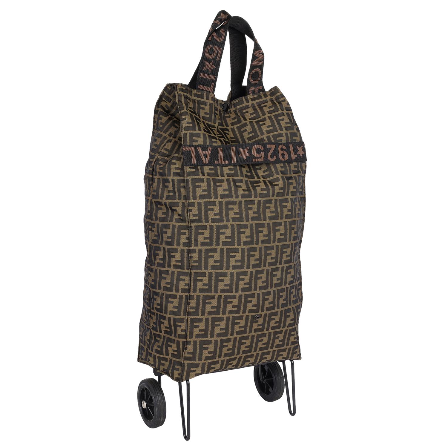 Authentic Fendi Jolly Zucca Traveler Shopping Roller with Wheels. Features Fendi Zucca canvas, top handles,  snap closure, 2 base feet and two wheels. This bag can be folded and carried by the hand or wheeled with your items inside. Perfect for