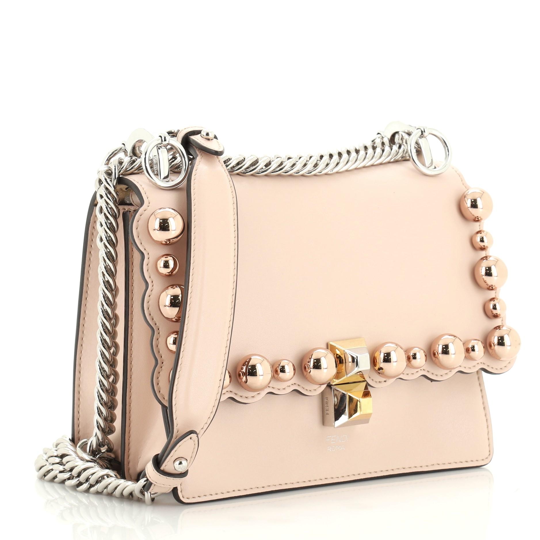 This Fendi Kan I Bag Studded Leather Small, crafted from pink studded leather, features sliding chain link shoulder strap with leather insert and silver-tone hardware. Its twist-lock closure opens to a neutral microfiber interior divided into two