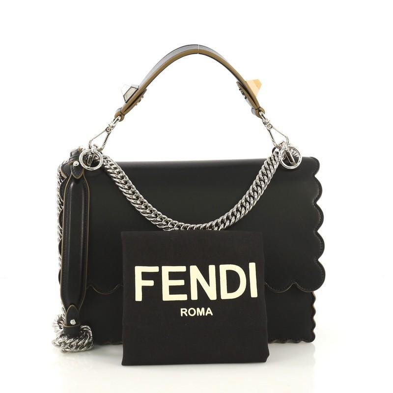 This Fendi Kan I Bag Leather Medium, crafted from black leather, features flat top handle with studs, long chain link shoulder strap with leather pad, scalloped trim, and silver-tone hardware. Its twist-lock closure opens to a black microfiber