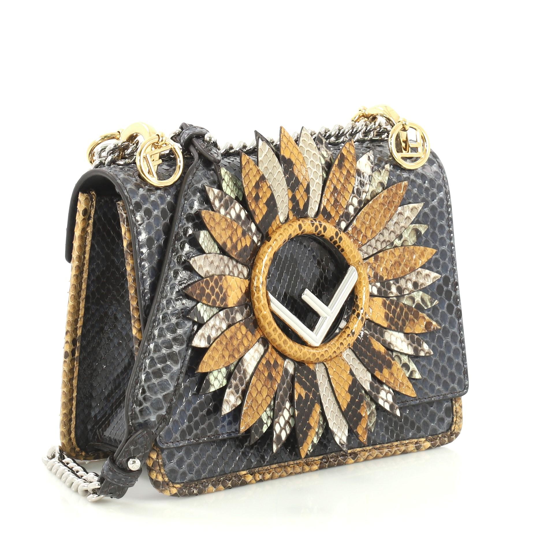 This Fendi Kan I F Shoulder Bag Embellished Python Small, crafted from genuine blue python, features a chain link strap with shoulder pad, Fendi logo, and silver-tone hardware. Its magnetic snap closure opens to a blue microfiber interior with slip
