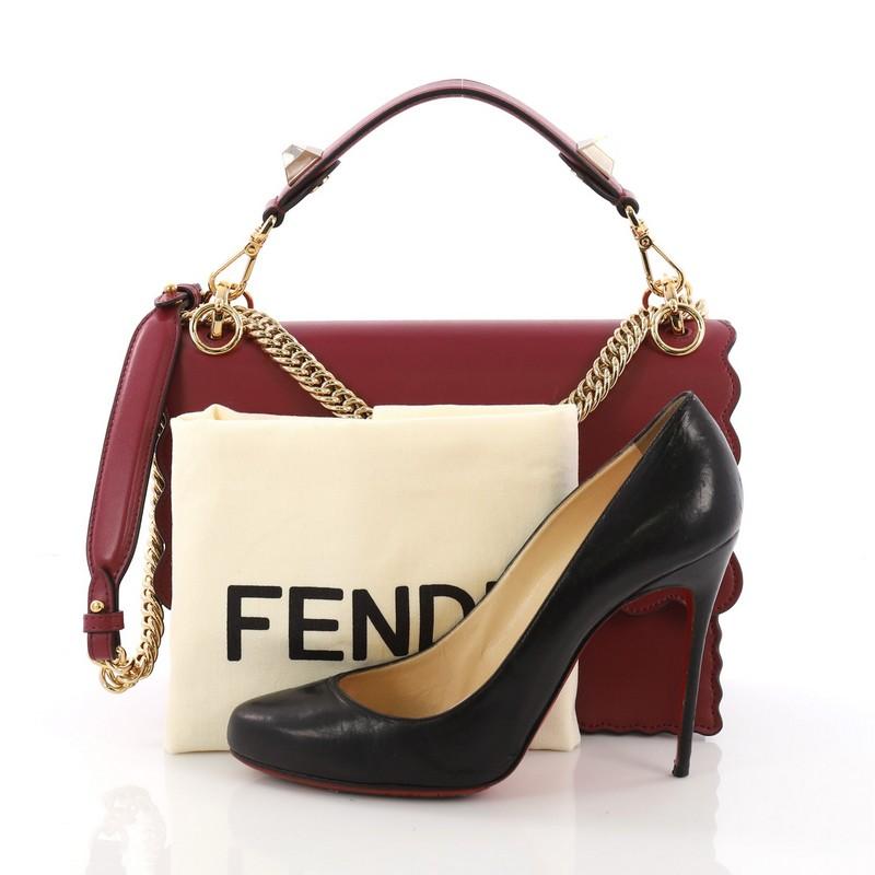This Fendi Kan I Handbag Leather Medium, crafted from purple leather with scalloped trims, features flat top handle with ABS studs, long chain link shoulder strap with leather insert, and gold-tone hardware. Its twist-lock closure opens to a beige