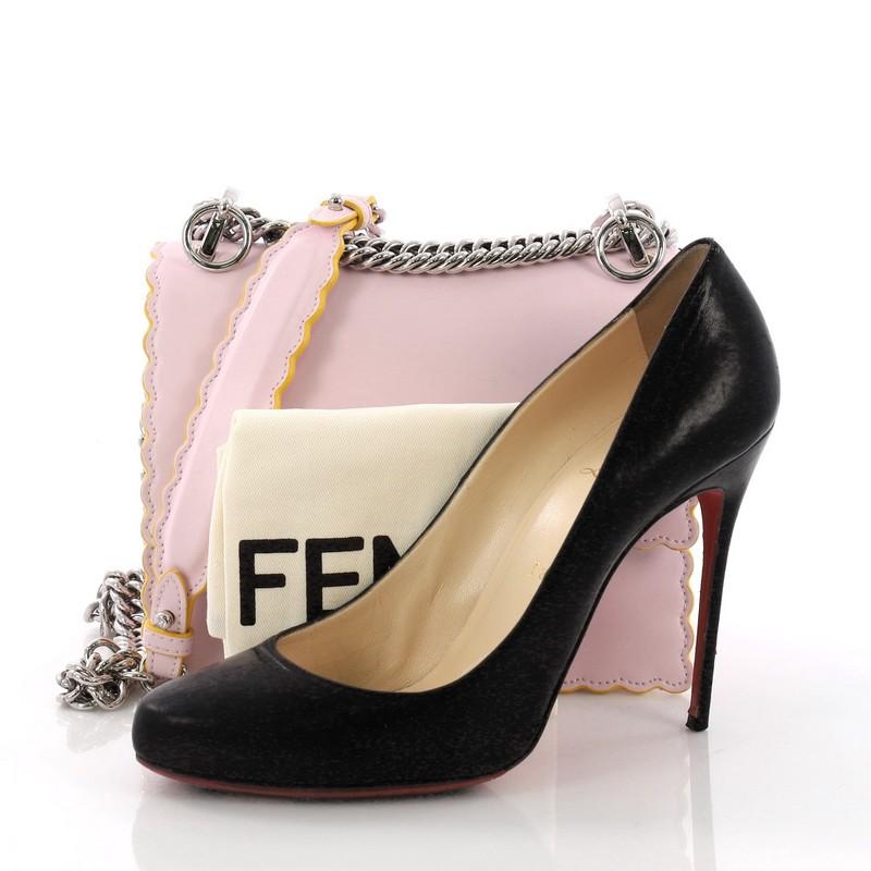 This Fendi Kan I Handbag Leather Small, crafted from pink leather, features a long sliding chain-link shoulder strap with leather insert, double stud two-tone plexiglass twist-lock closure, and silver-tone hardware. Its twist-lock closure opens to a