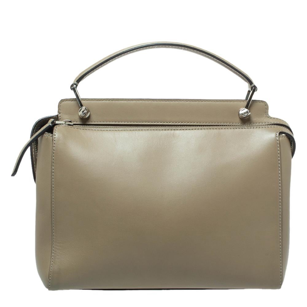 We are in love with this Dotcom bag from Fendi. Wonderfully crafted from leather, the bag has a silhouette that is functional. It has a plain exterior, and the top zipper reveals suede interiors spacious enough to carry your essentials. The khaki