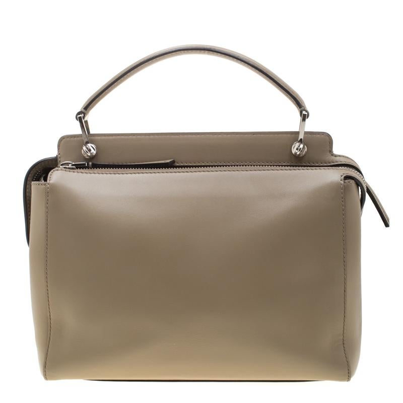 The Dotcom bags from Fendi were first introduced in their Resort 2016 collection. This bag in a khaki hue has a structured silhouette with an extended top. The signature silver-tone dot appears right in its place on the front. Crafted from leather,