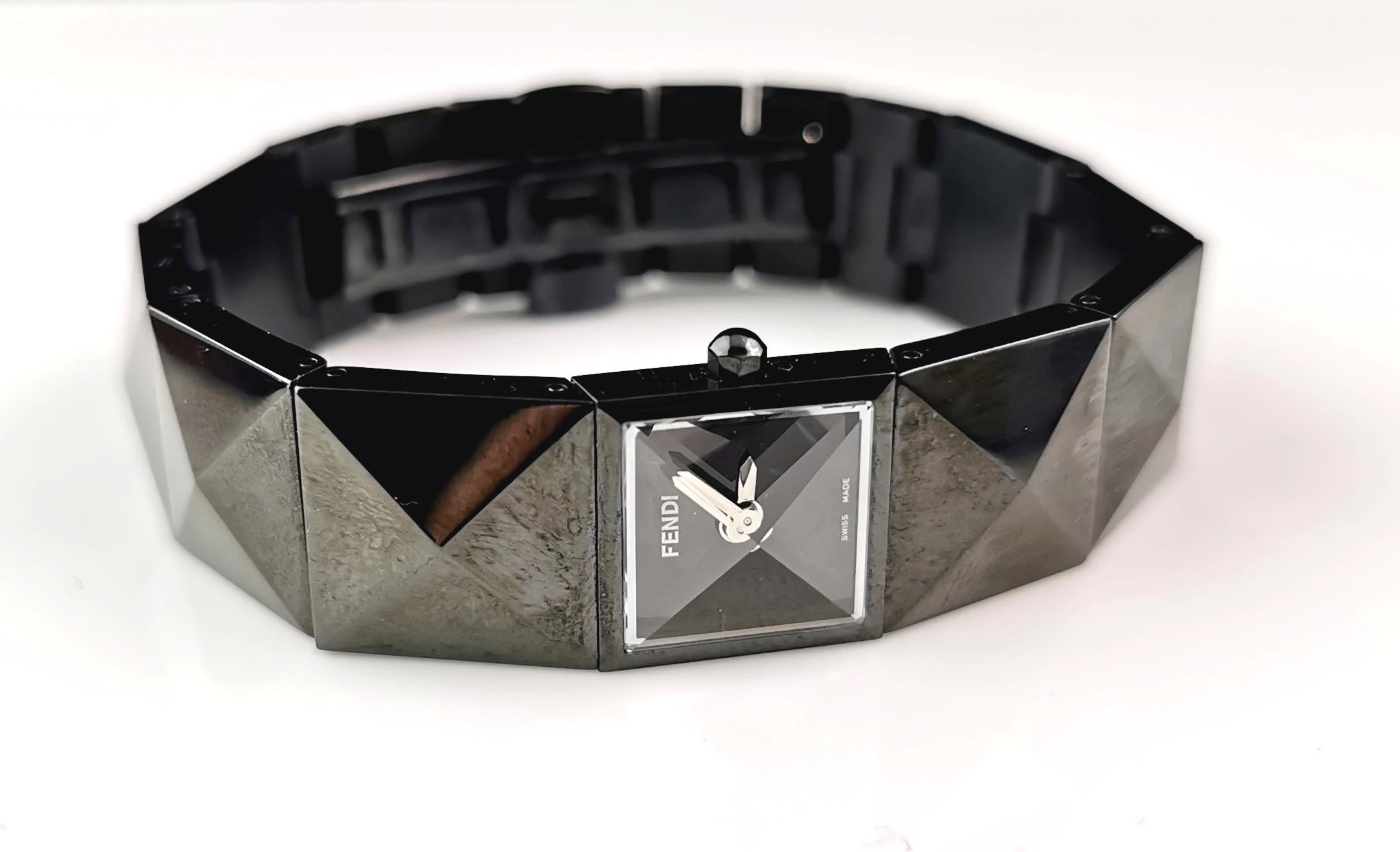 A stylish and iconic ladies Fendi 4270 l wristwatch.

It is a black ion plated steel bracelet watch with a unique pyramid design link that really makes this watch stand out.

It has a small pyramid domed glazed dial, the dial in black with silver