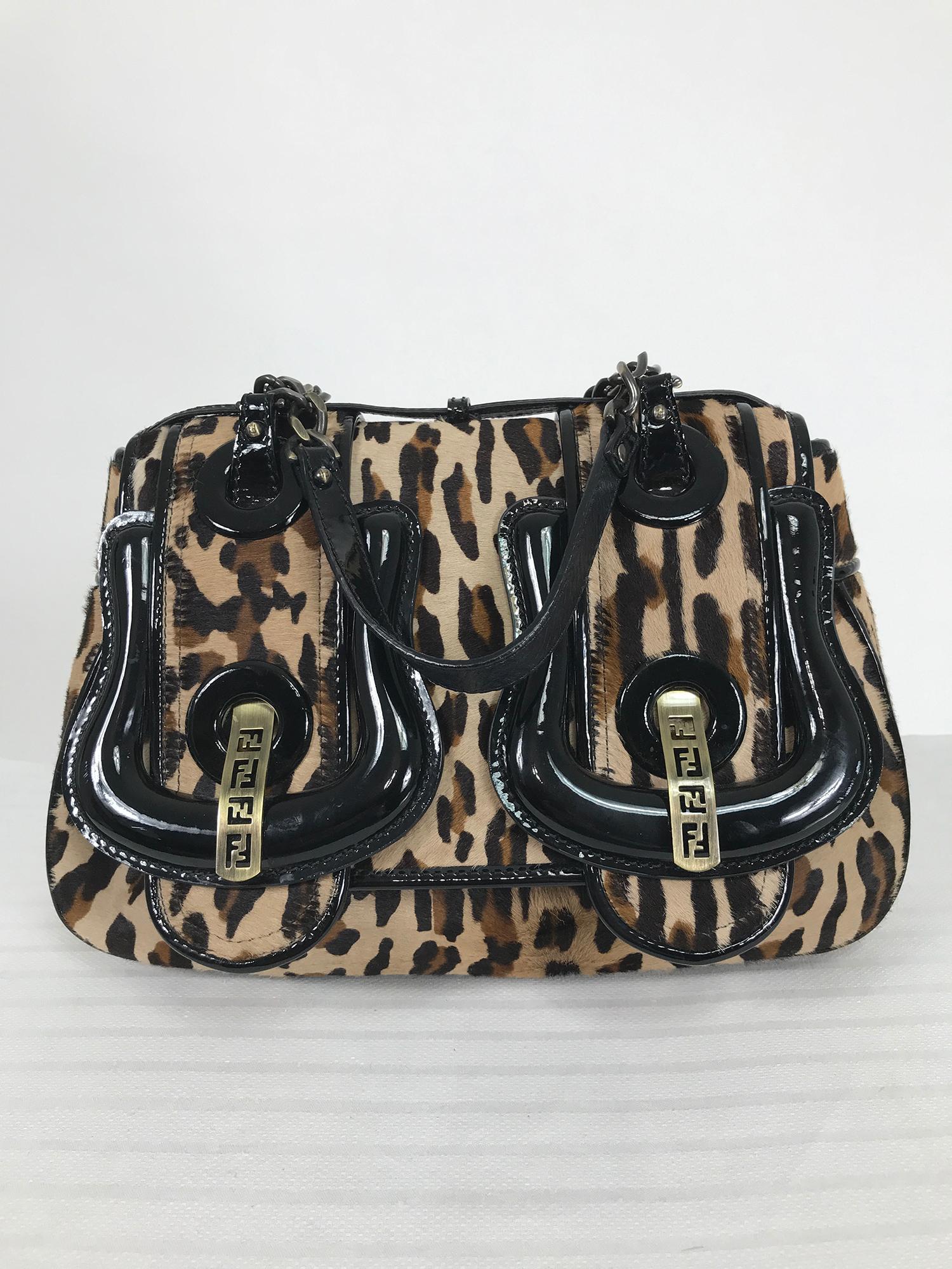 Fendi leopard print calf hair and black patent leather B Bag.  It features luxurious glossy patent leather contrasted with leopard printed calf hair. Double Fendi buckles sit at the front and the chain link shoulder straps complete the look. Flap