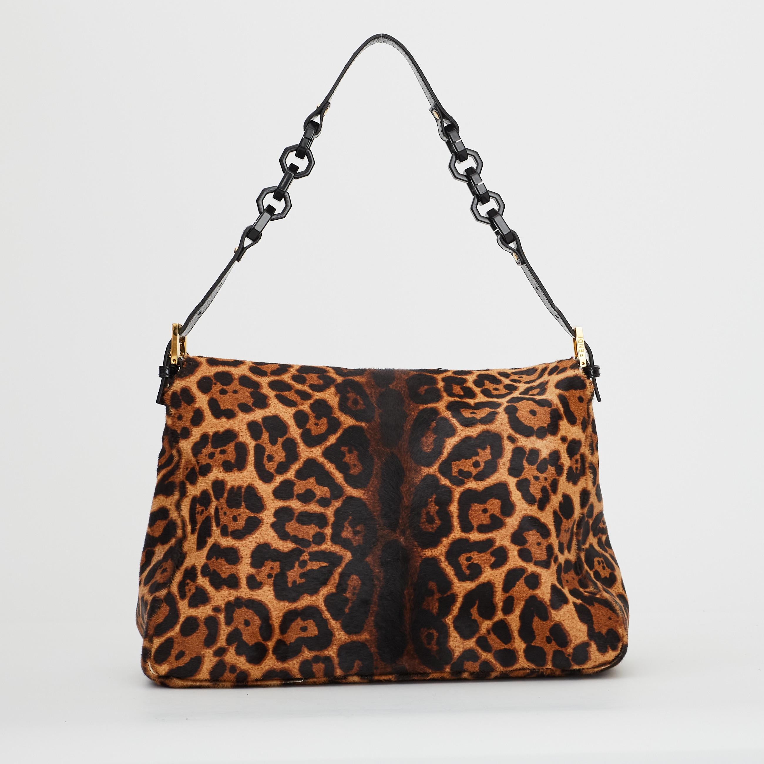 This mama baguette is made of light brown leopard print calf hair. The bag features shoulder link shoulder strap of resin with a leather shoulder pad, a front flap with a resin FF detail on the flap buckle, snap closure and woven fabric interior