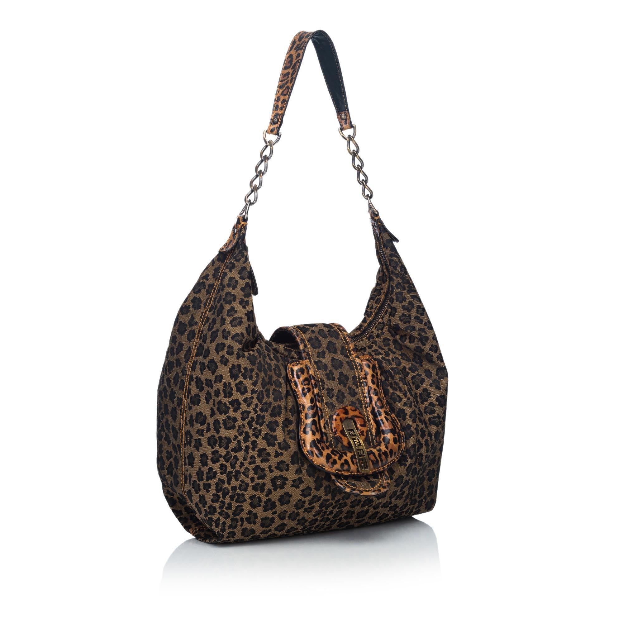 The Fendi B. Bag Hobo features a canvas body with all over leopard print, flat leather and chain strap, top zip closure, front buckle with magnetic snap closure, and interior slip pockets. 

Strap drop: 33 cm. 
