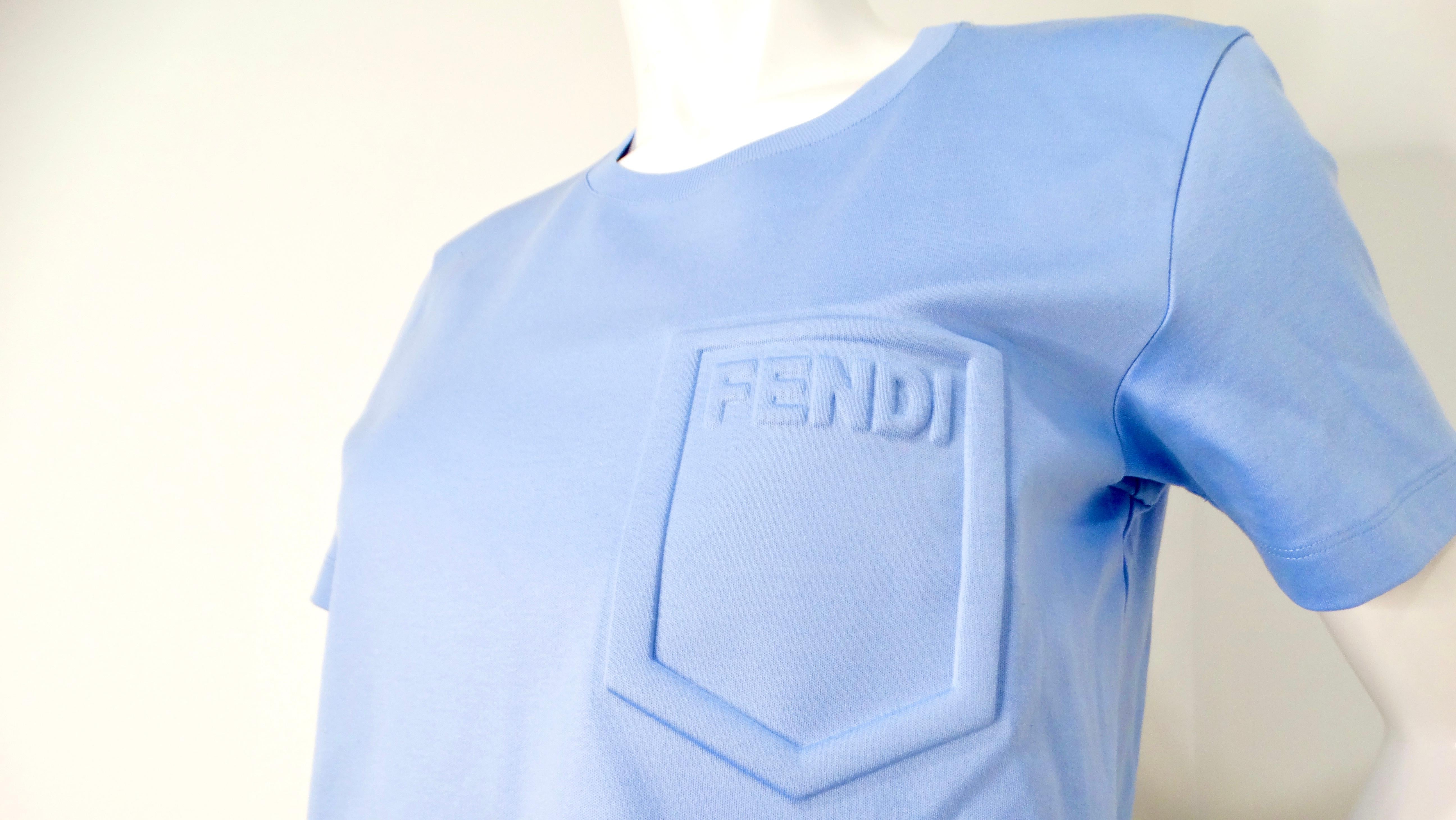 La T-Shirt Fendi Light Blue Cotton Logo Embossed Crop Top è un'aggiunta elegante e chic a qualsiasi guardaroba alla moda. Realizzato in cotone di alta qualità, questo capo presenta un logo in rilievo che cattura l'essenza dello streetwear di lusso.