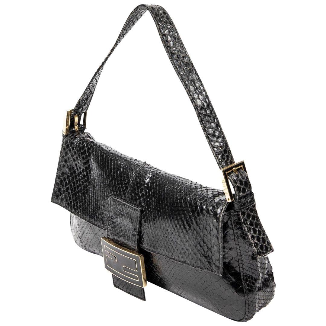 A vintage handbag collector's dream! This Fendi Baguette is sooo special. Rendered in black snakeskin with gold-tone hardware, a single tonal flat shoulder strap with dual buckle adjustments. The magnetic snap closure at the front opens up to a