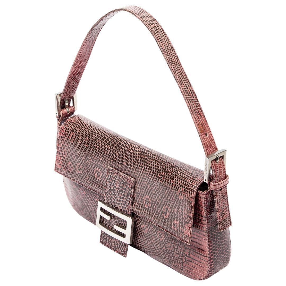 As seen on PARIS HILTON!!! The Fendi Lizard Embossed Baguette in pink boasts a luxurious lizard-embossed leather with silver accents. A satin interior awaits within, secured by a magnetic snap and complete with a zippered pocket.

SPECIFICS
•