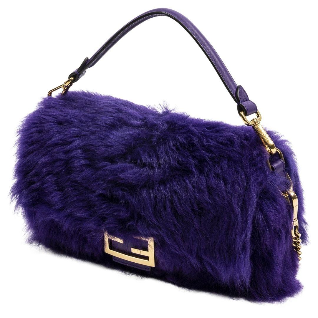 Everything is better in PURPLE. This limited edition is crafted in purple fur, gold-tone hardware, an optional leather top handle, and adjustable shoulder strap. The magnetic snap closure opens to a canvas lining and one zipped pocket. The bag is a