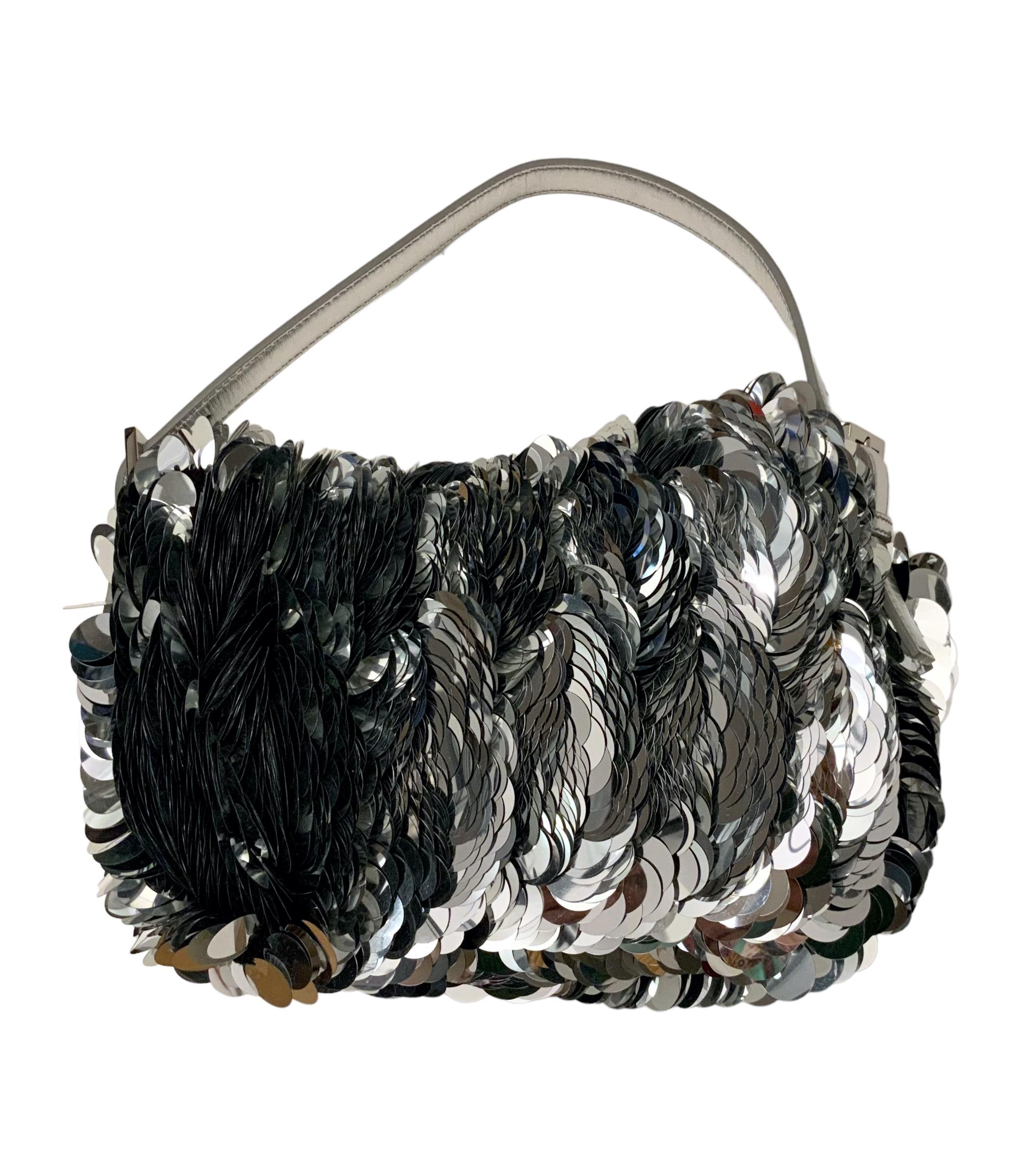 This pre-owned Baguette from the house of Fendi is an iconic piece !
Crafted of XXL silver paillette sequin on a black crochet knit bag base. 
It features a silver leather handle, a silver buckle with the Fendi emblem and a closure tab. 
Comes with