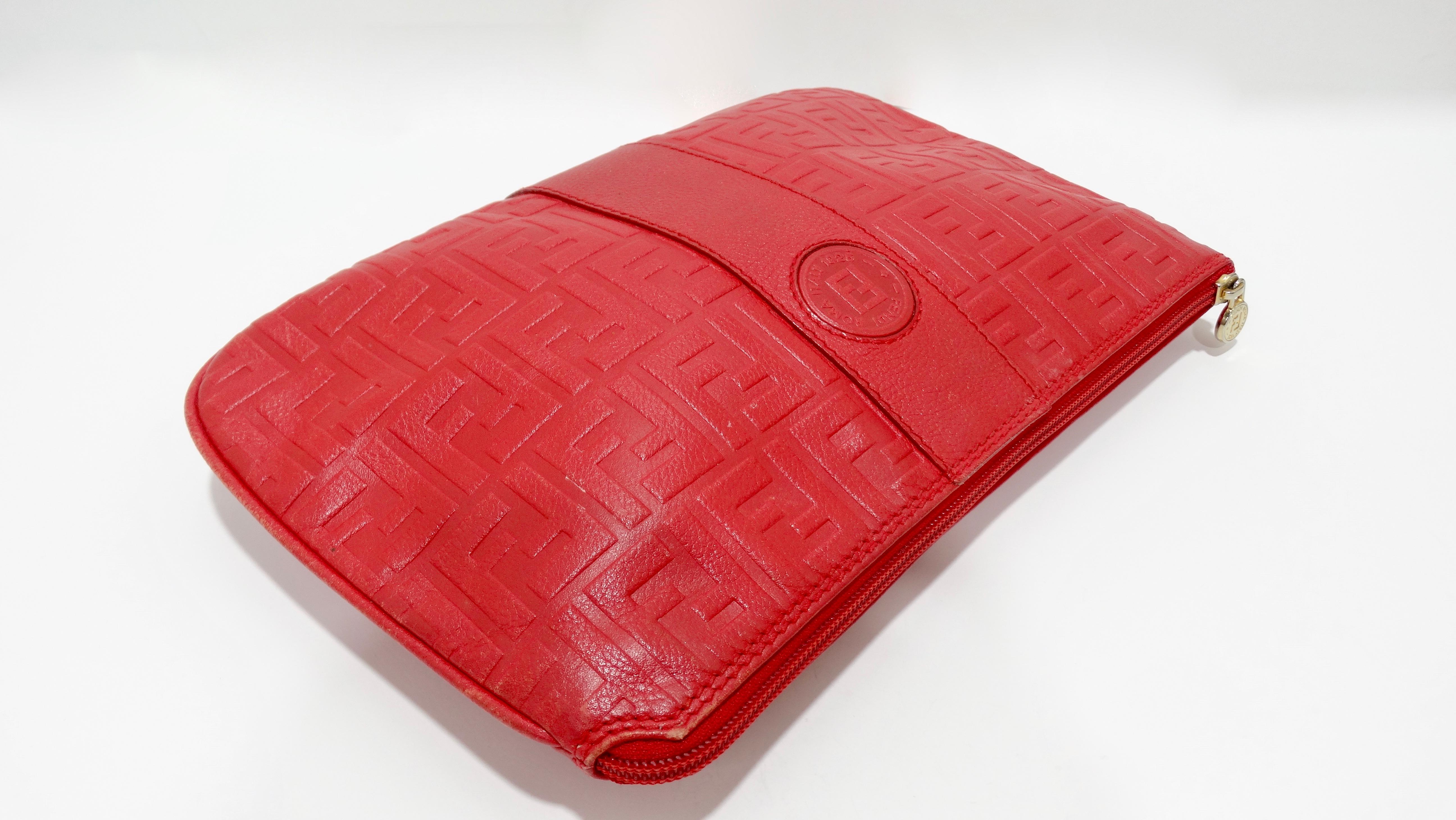 This Fendi is calling your name! Circa late 80s/early 90s, this large clutch is crafted from lipstick red leather and is embossed allover with the iconic Fendi monogram. Features gold hardware, a stamped zipper pull and on the front face is a