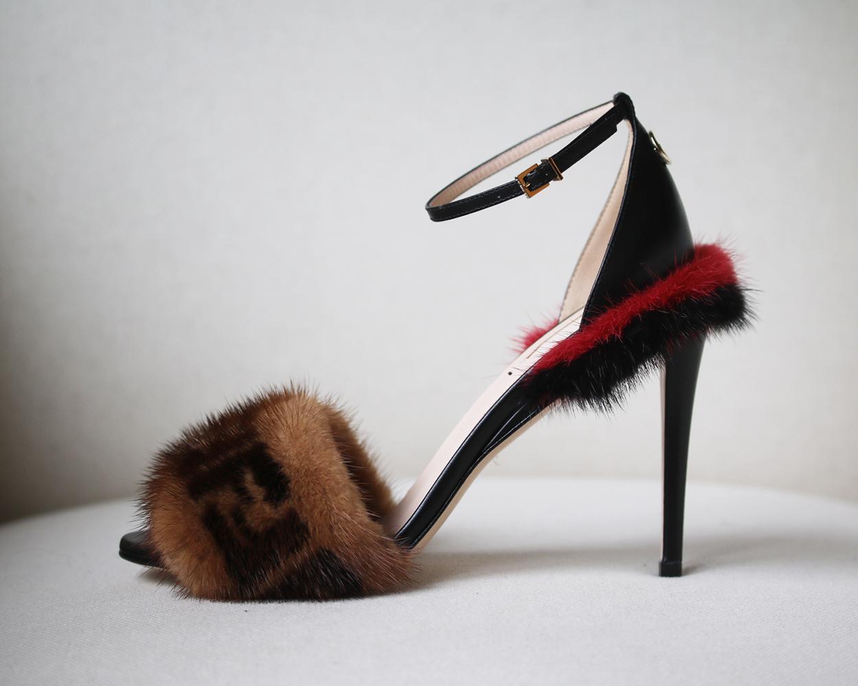 Fendi's iconic FF logo gets upgraded in lush mink fur on a fabulously fun ankle-strap sandal made in Italy. Buckle fastening on the ankle. Leather heel and strap. Mink trimmed detail. Color: brown. Heel measures approx. 4 inches. Does not come with
