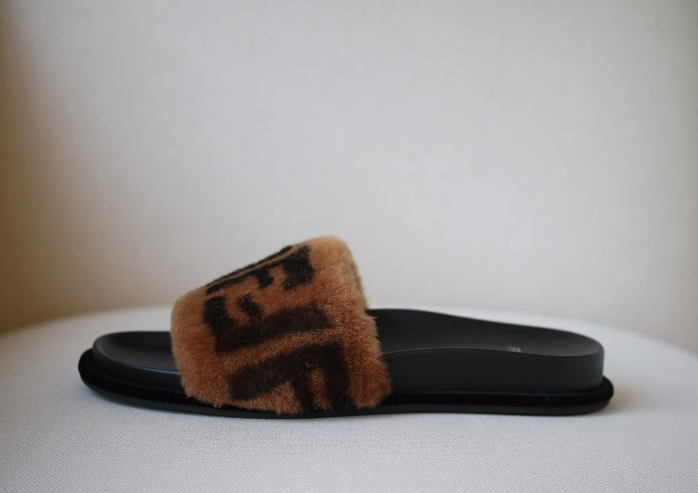 Slides with high band. The high band is made of brown sheepskin with the FF motif printed in black and brown. The welt is finished with visible stitching. Tone-on-tone and anti-slip sole. Made in Italy. 100% sheep fur, inside: 100%lamb