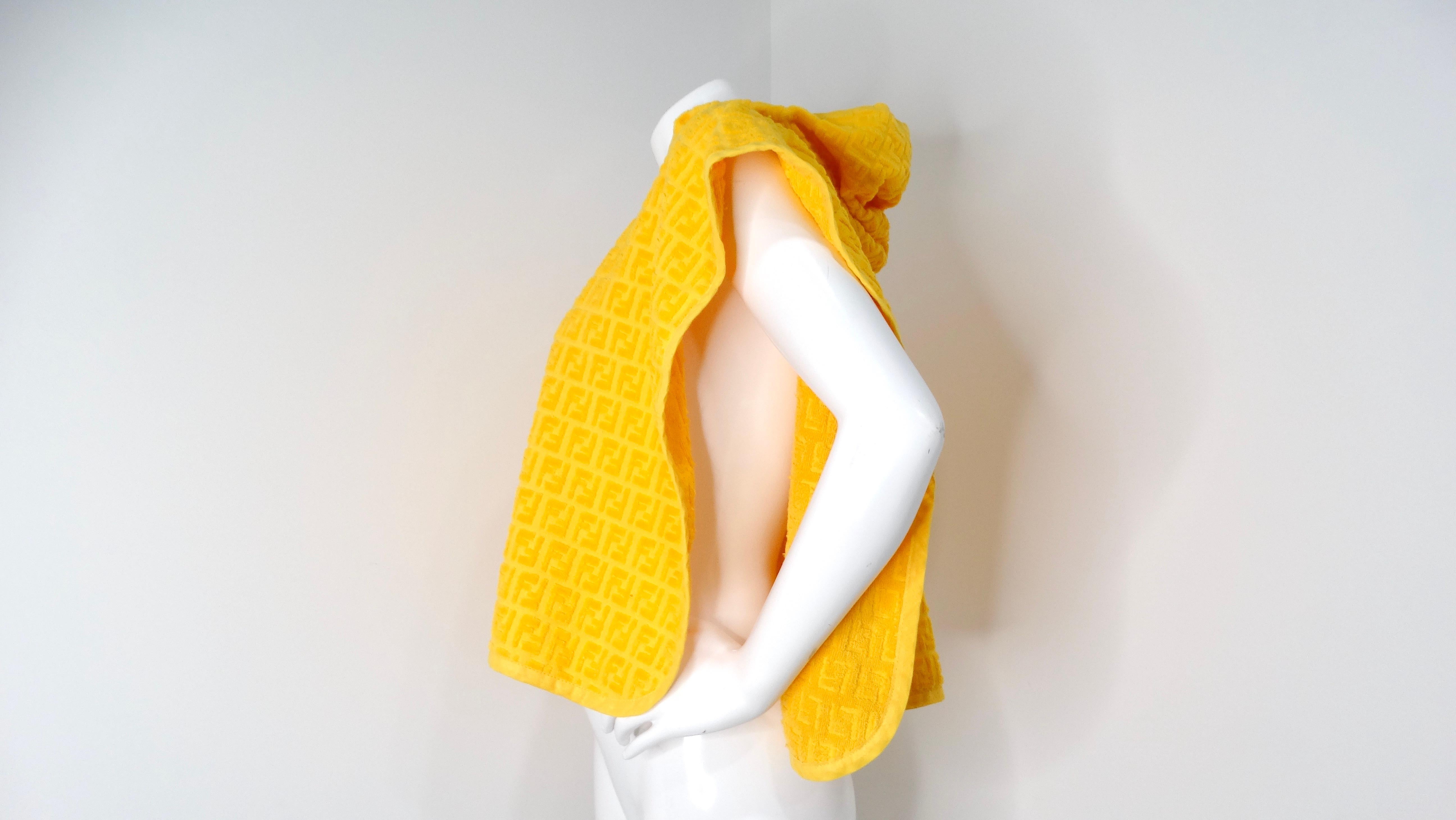 The Fendi Logo Yellow Terrycloth Poncho is a vibrant and luxurious statement piece that exudes a laid-back, contemporary style. Crafted from 100% cotton terrycloth, this poncho features an all-over Fendi logo pattern that showcases the brand's