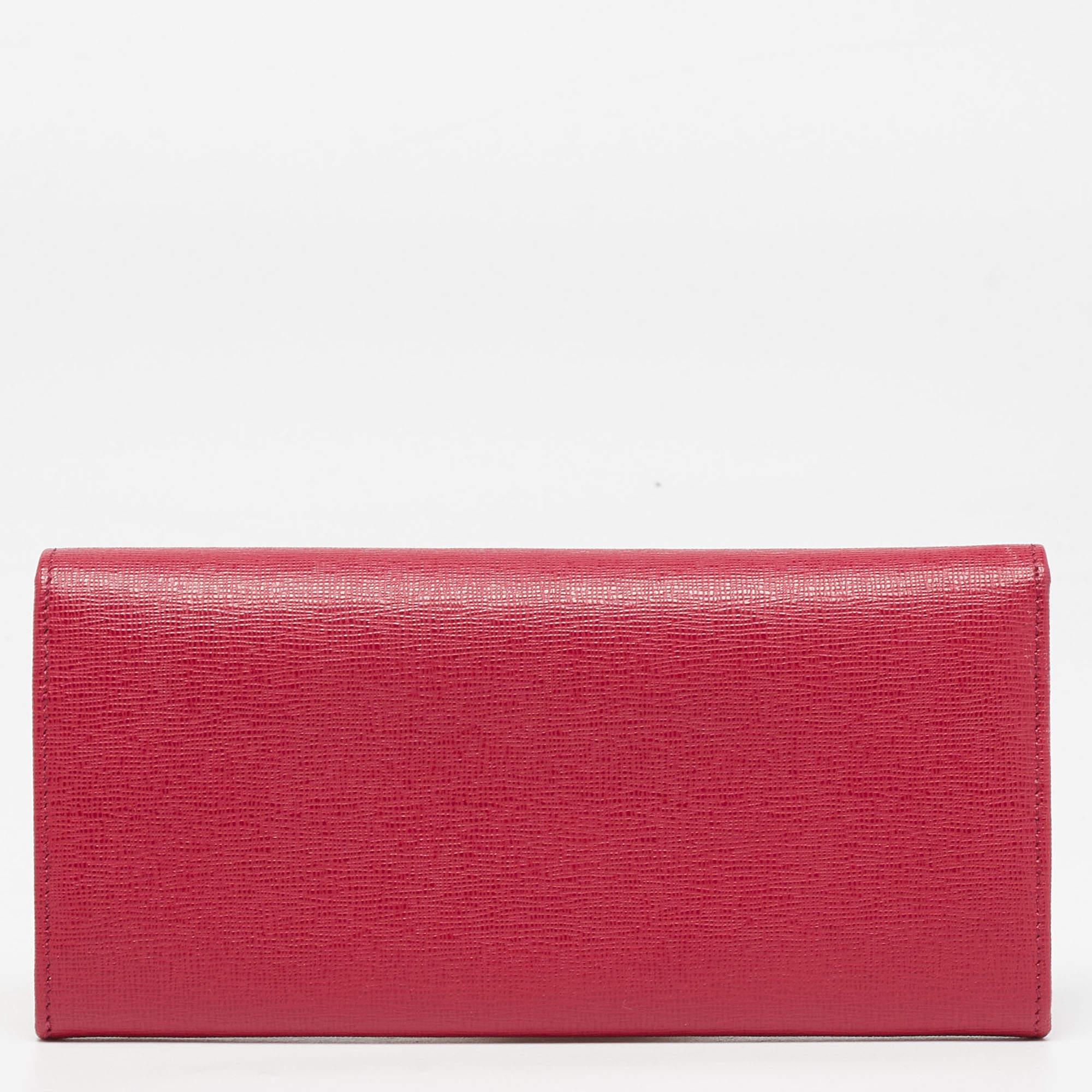 This Fendi wallet is the perfect pick to organize your things. Crafted from leather, this red wallet is accented with gold-tone hardware. The flap closure with concealed fastening features a brand plaque. The leather and fabric lined interior houses
