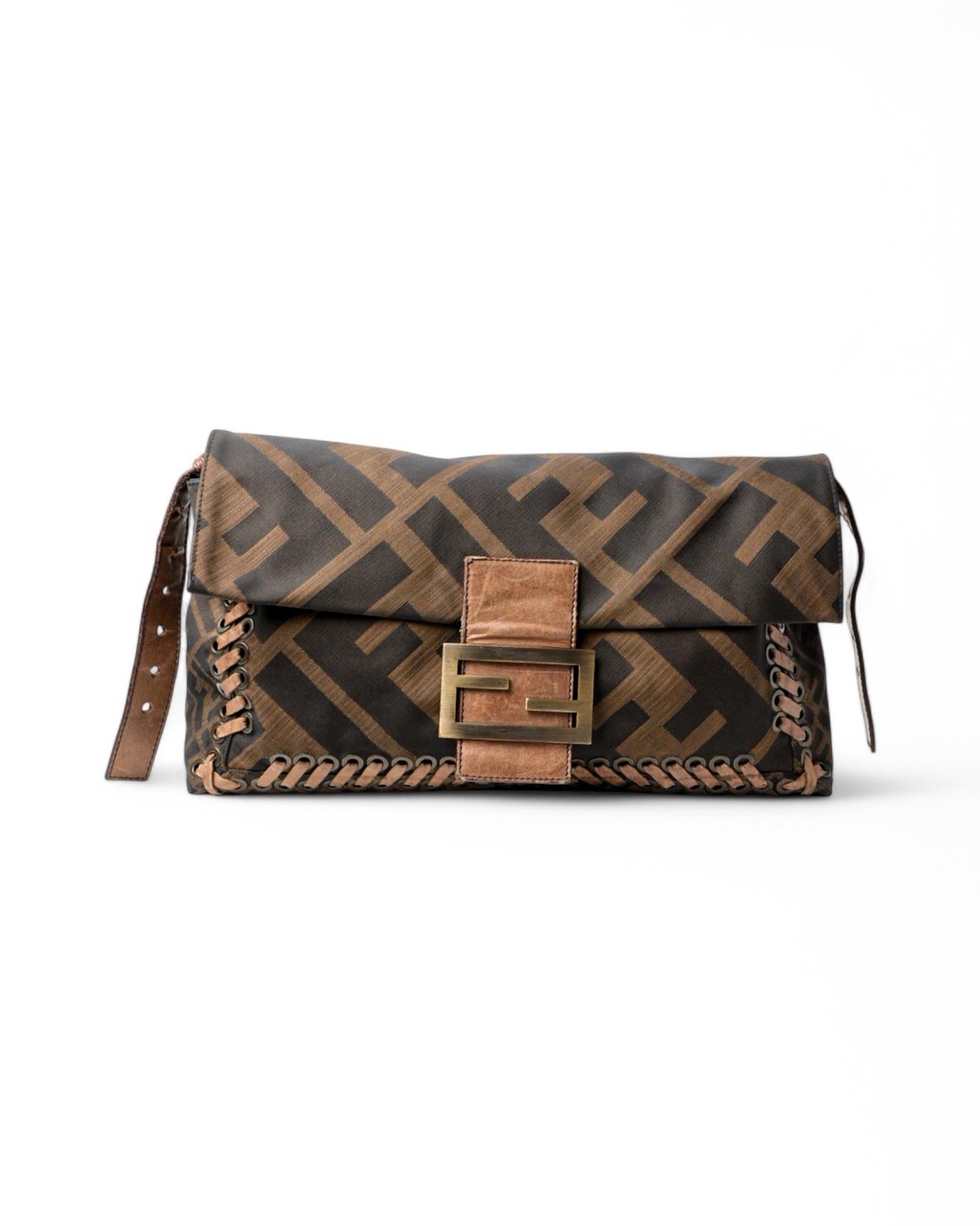 Sac signé Fendi, modèle Mama Baguette en grand format, réalisé en toile au motif classique FF Logoania avec empiècements en cuir et ferrures dorées. Il est doté d'un rabat avec le logo classique de la marque FF en métal et d'une fermeture à bouton