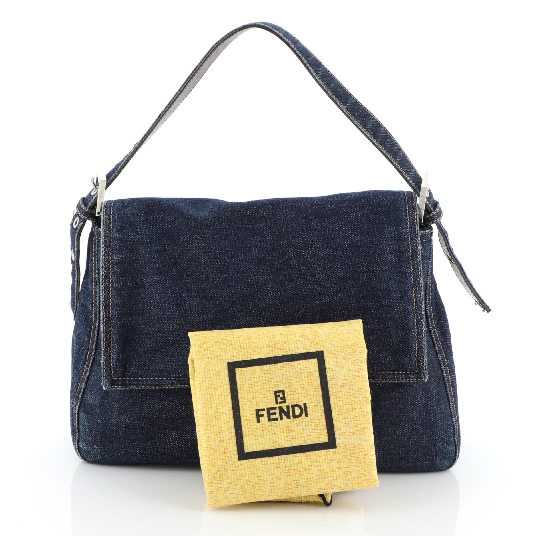 This Fendi Mama Forever Bag Denim, crafted from blue denim, features a flat denim strap, stylized Fendi hardware detailing, and silver-tone hardware. Its hidden magnetic snap closure opens to a brown fabric interior with side zip pocket 

Condition: