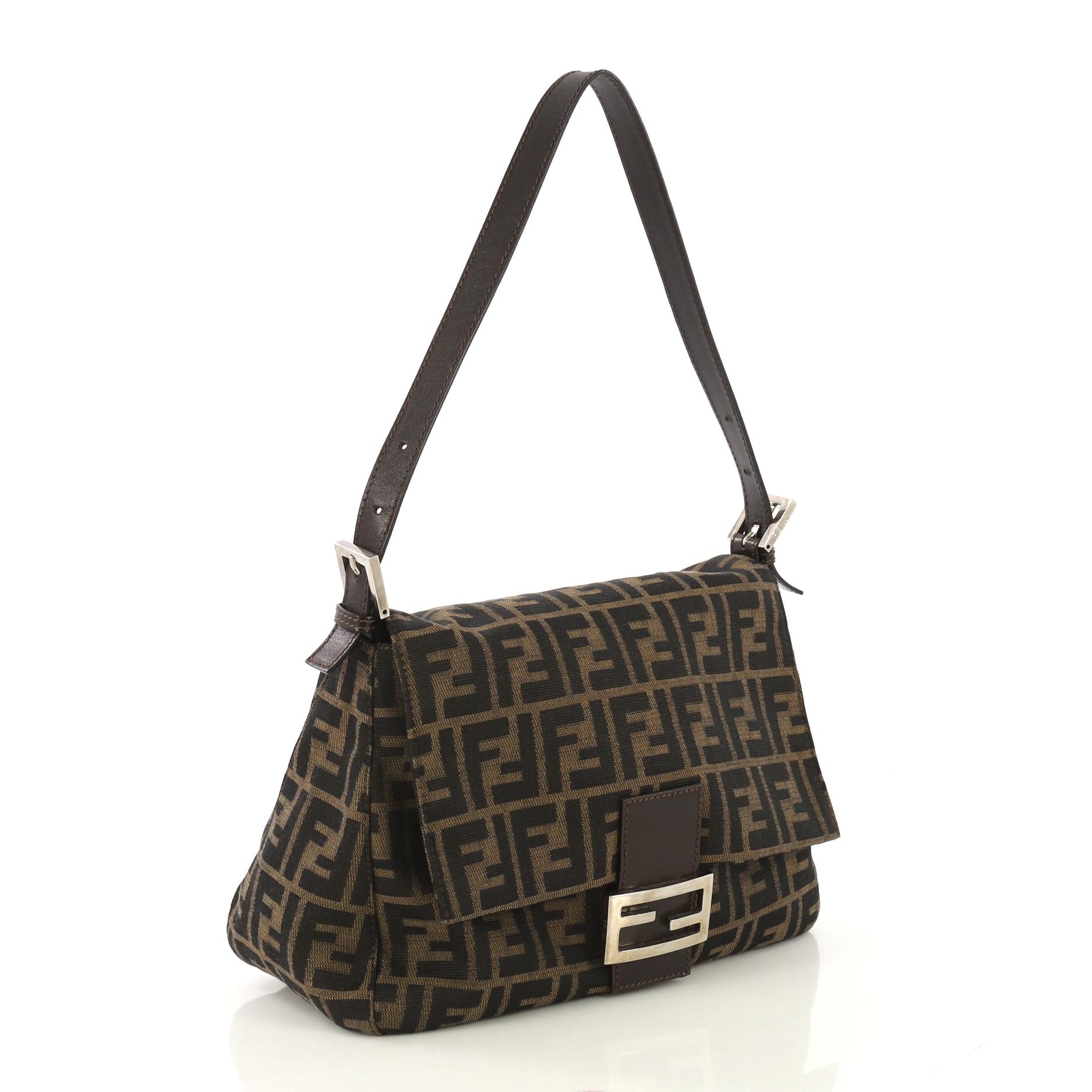 This Fendi Mama Forever Bag Zucca Canvas, crafted from brown zucca canvas, features a flat leather strap, Fendi logo detailing, and silver-tone hardware. Its hidden magnetic snap closure opens to a brown fabric interior with side zip pocket.