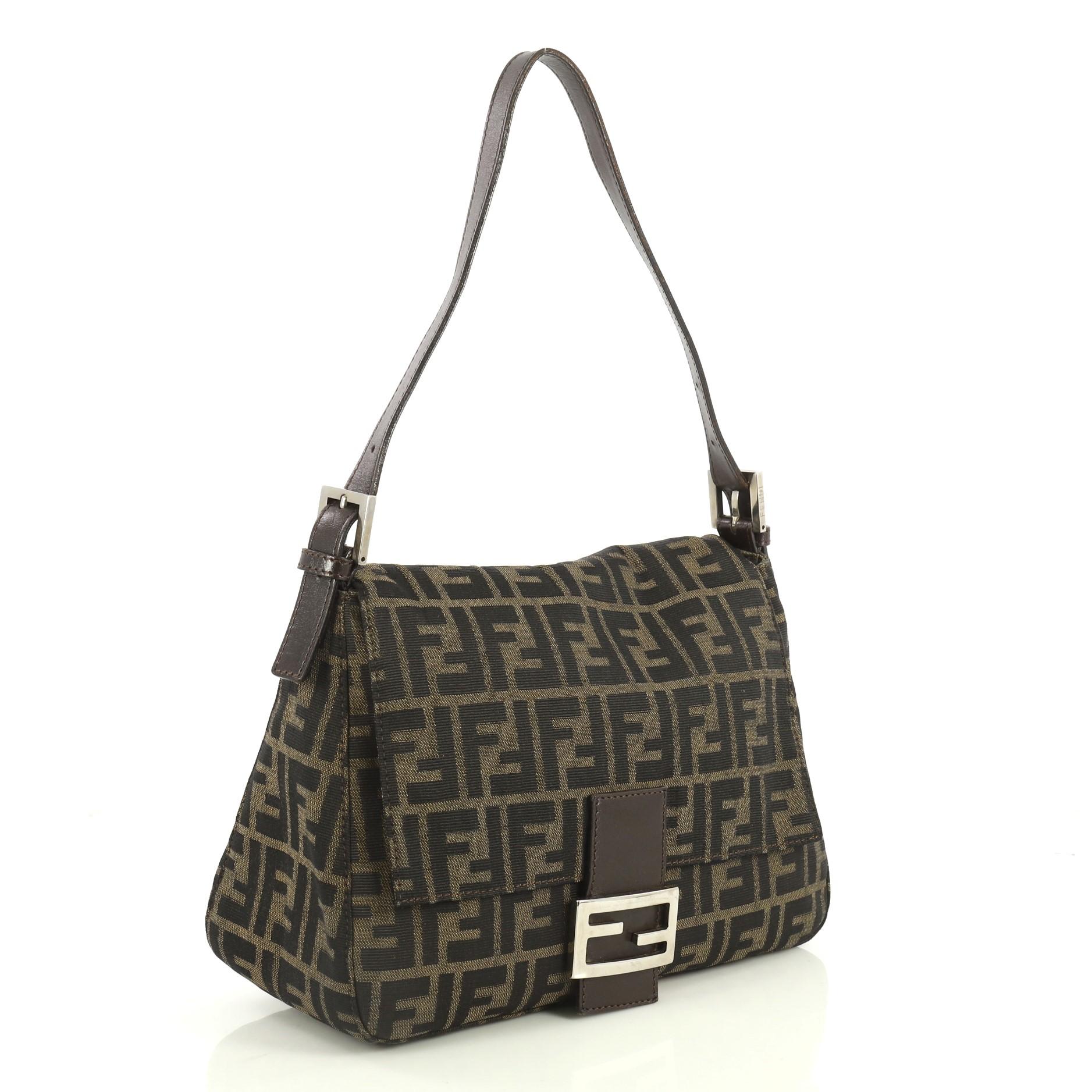This Fendi Mama Forever Bag Zucca Canvas, crafted from brown zucca canvas, features a flat leather strap, Fendi logo detailing, and silver-tone hardware. Its hidden magnetic snap closure opens to a brown fabric interior with side zip