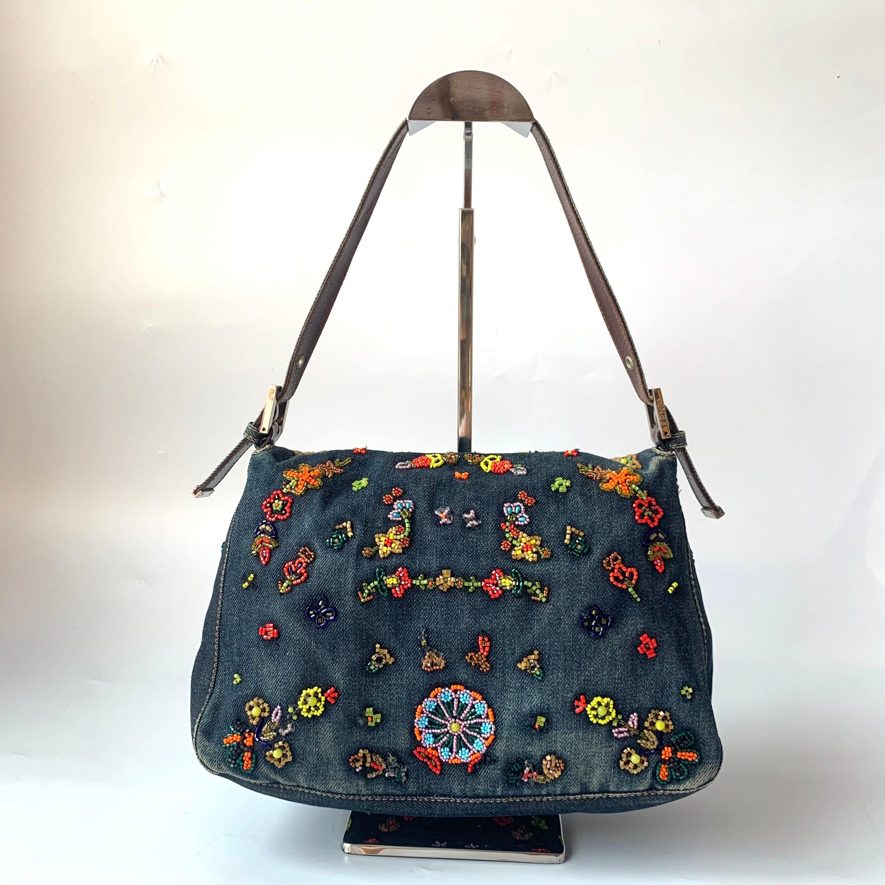 FENDI Mamma Baguette Blue Denim with Floral Beads
These are professional photos of the actual bag.
  Vintage Fendi Mamma Baguette in Blue Denim With beaded Flower embroidery, removable leather strap, silk yellow lining. One of the most iconic